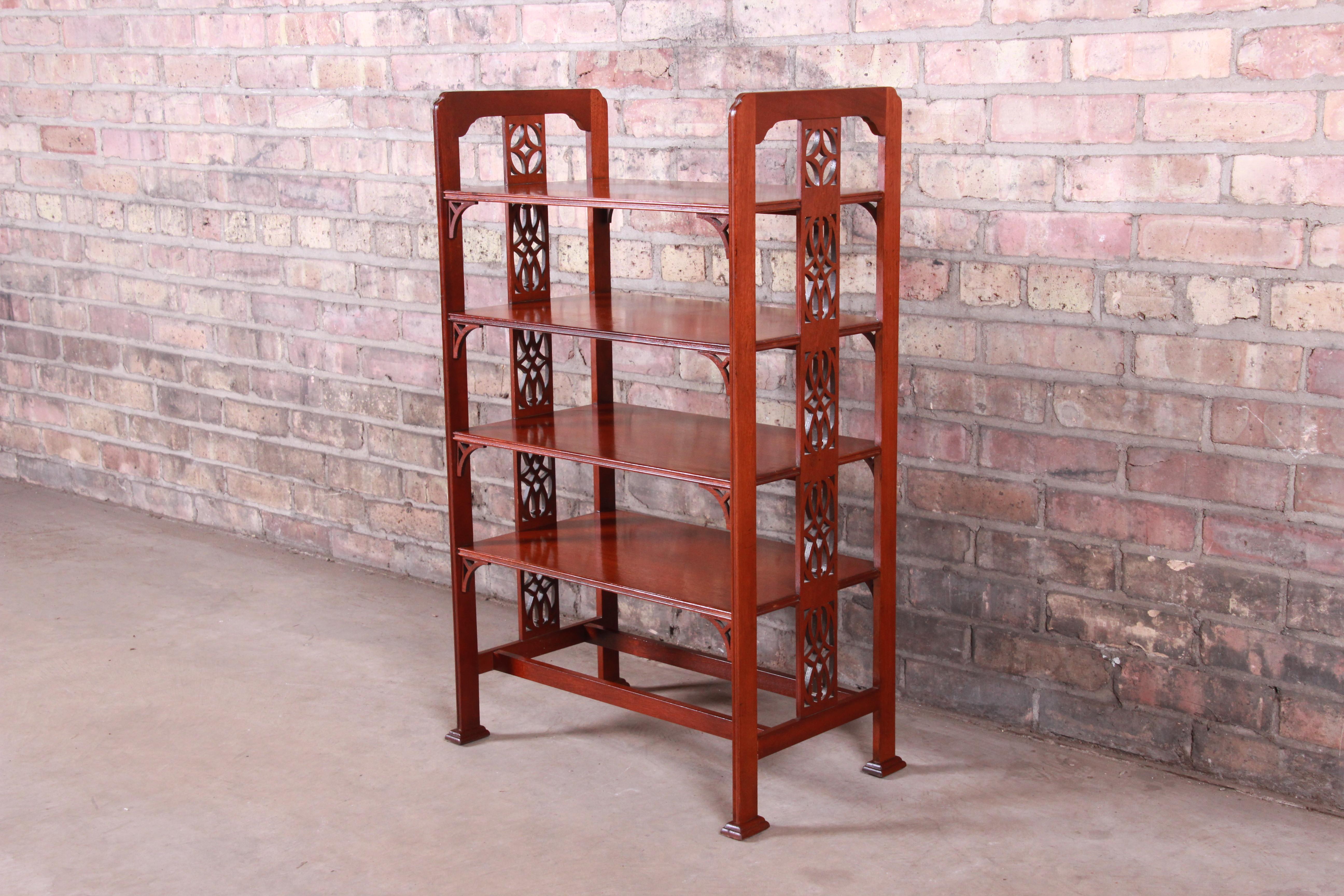 An exceptional carved mahogany four-tier étagère or occasional side table

By Baker Furniture 