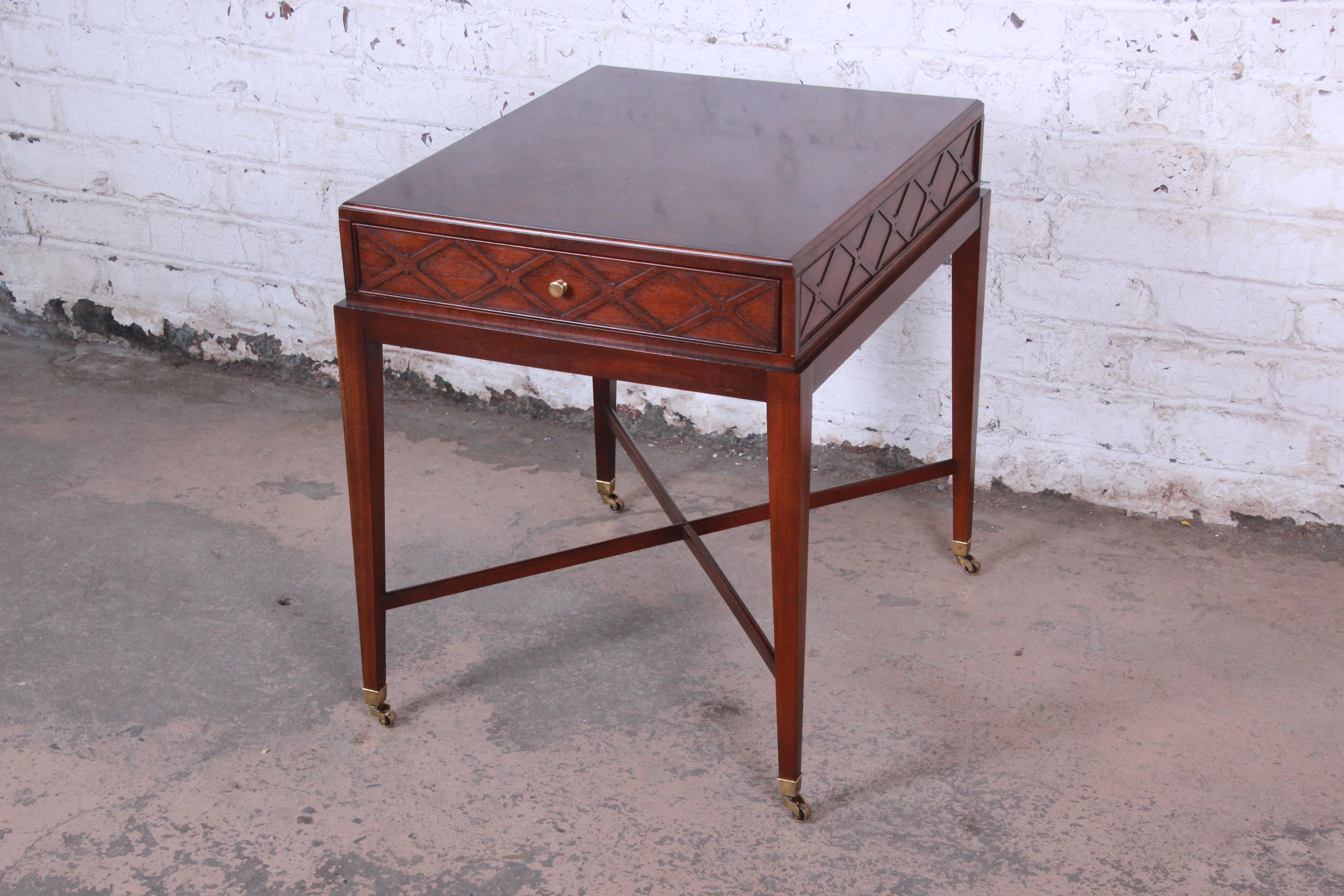 Offering an exceptional colonial reproduction inlaid mahogany side table from the Historic Charleston Collection by Baker Furniture. The table features gorgeous mahogany wood grain and a unique x-base design. It has a single drawer for storage and