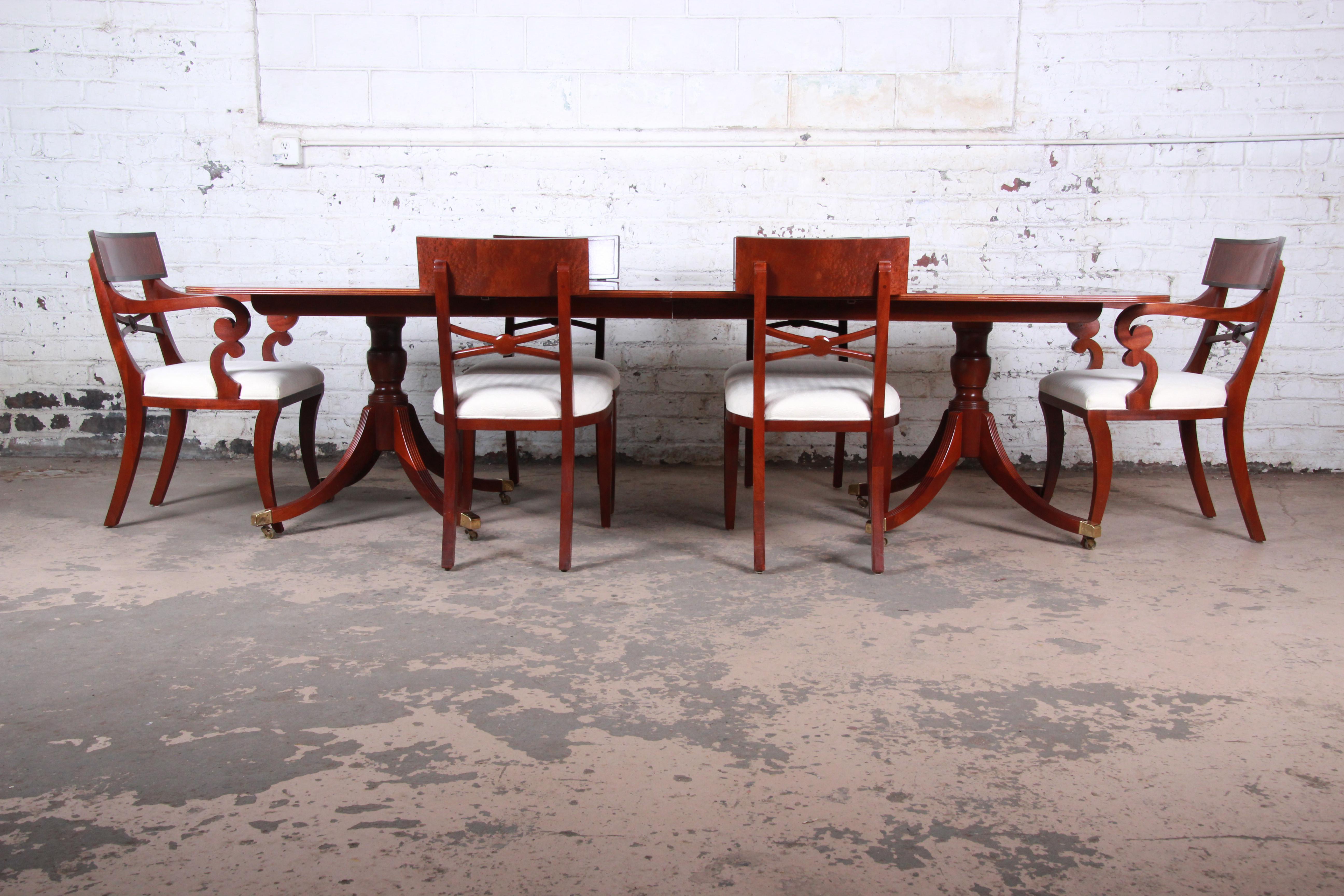 An exceptional Georgian banded and inlaid mahogany dining table and chairs from the Historic Charleston Collection by Baker Furniture. The set includes the extension dining table with two leaves and six chairs. The double pedestal table features
