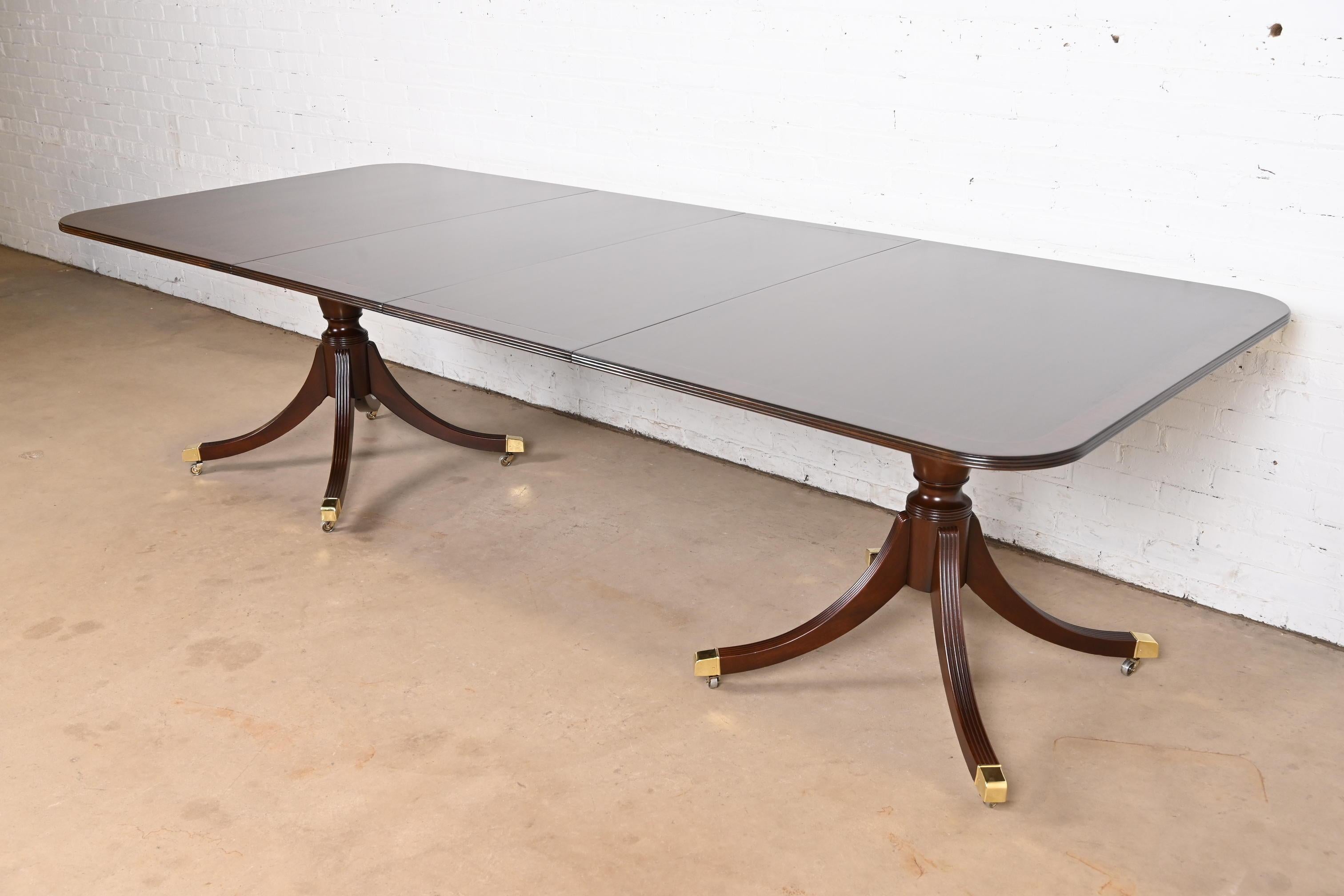 Exceptionnelle table à manger à rallonge à double piédestal de style Géorgien ou Régence.

Par Baker Furniture, collection 