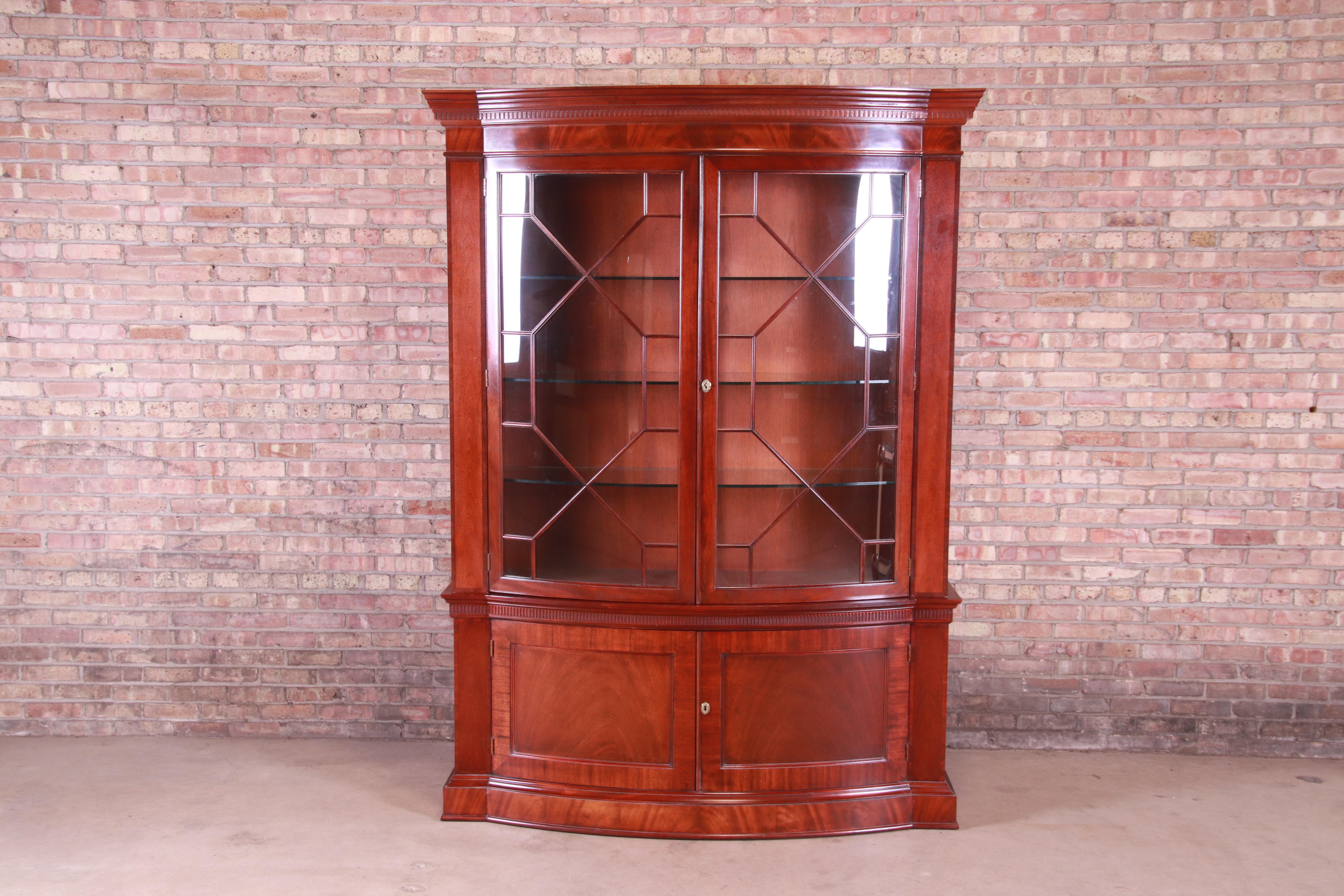 An exceptional Georgian lighted bow front bookcase or bar cabinet

By Baker Furniture 