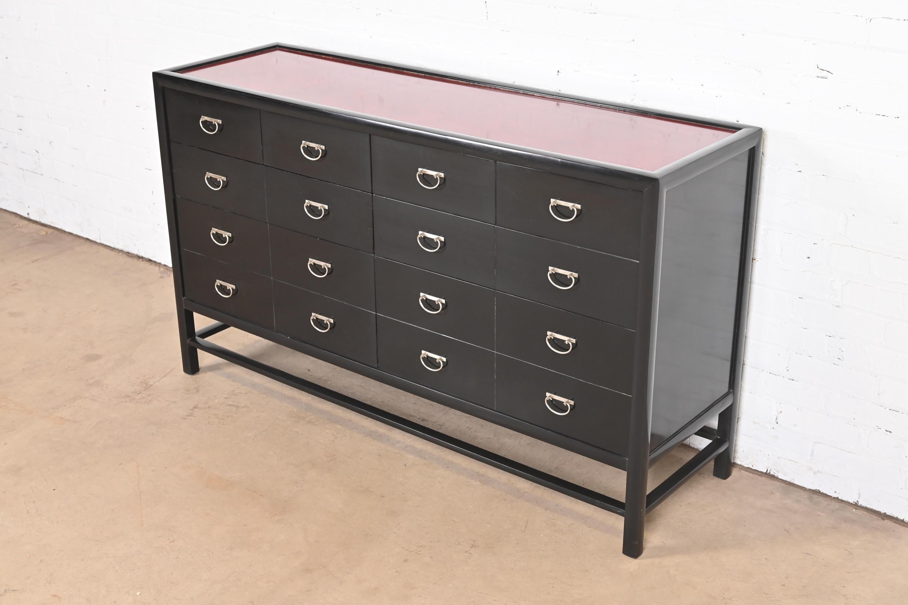 A gorgeous Hollywood Regency Chinoiserie style eight-drawer dresser or chest of drawers

By Baker Furniture

USA, Circa Late 20th Century

Black lacquered case, with red lacquered top, and Asian-inspired nickel hardware.

Measures: 57.25