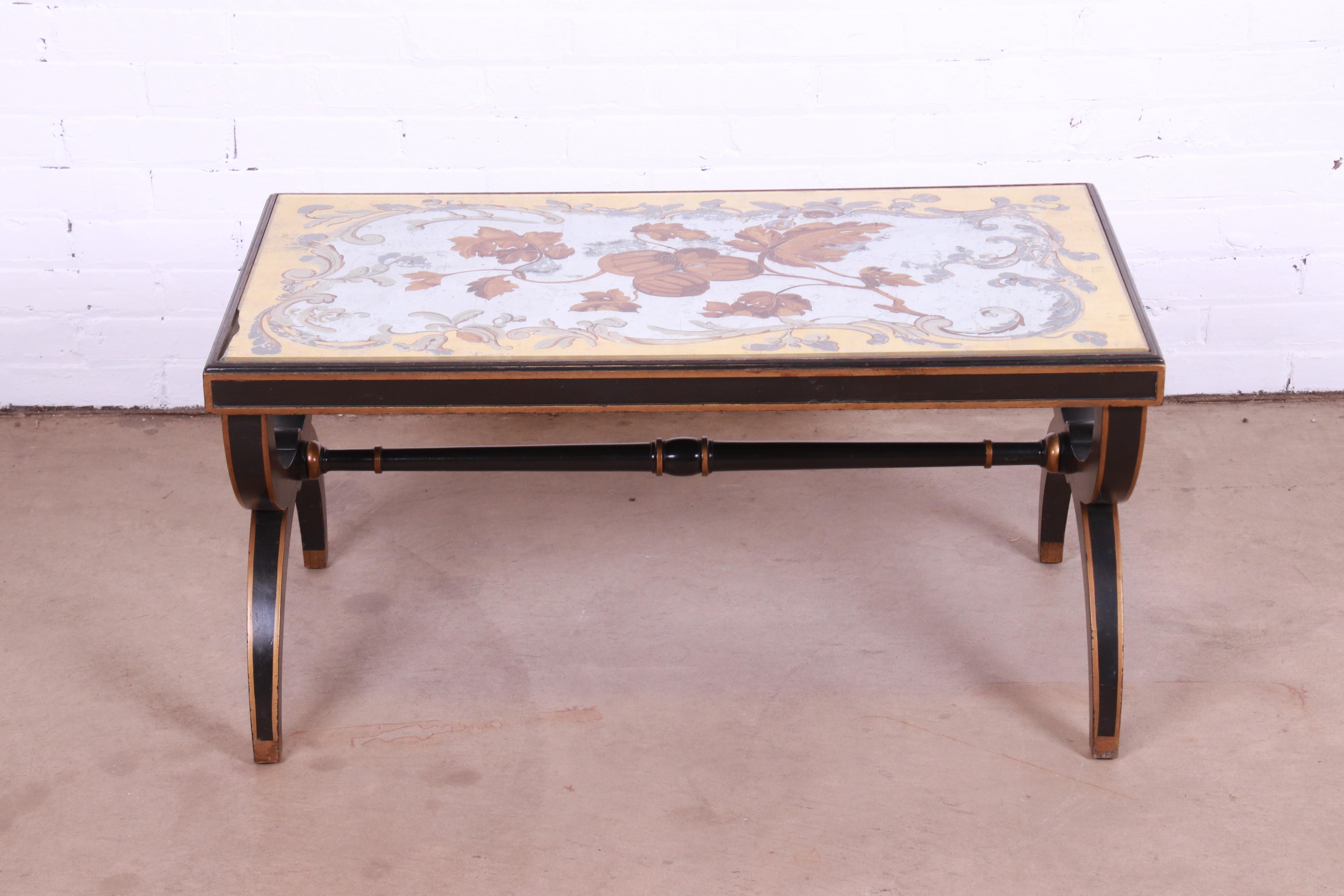 A gorgeous mid-century Hollywood Regency coffee or cocktail table

By Baker Furniture

USA, Circa 1940s

Ebonized and gold gilt wood frame, with reverse painted mirrored glass top in floral design.

Measures: 37