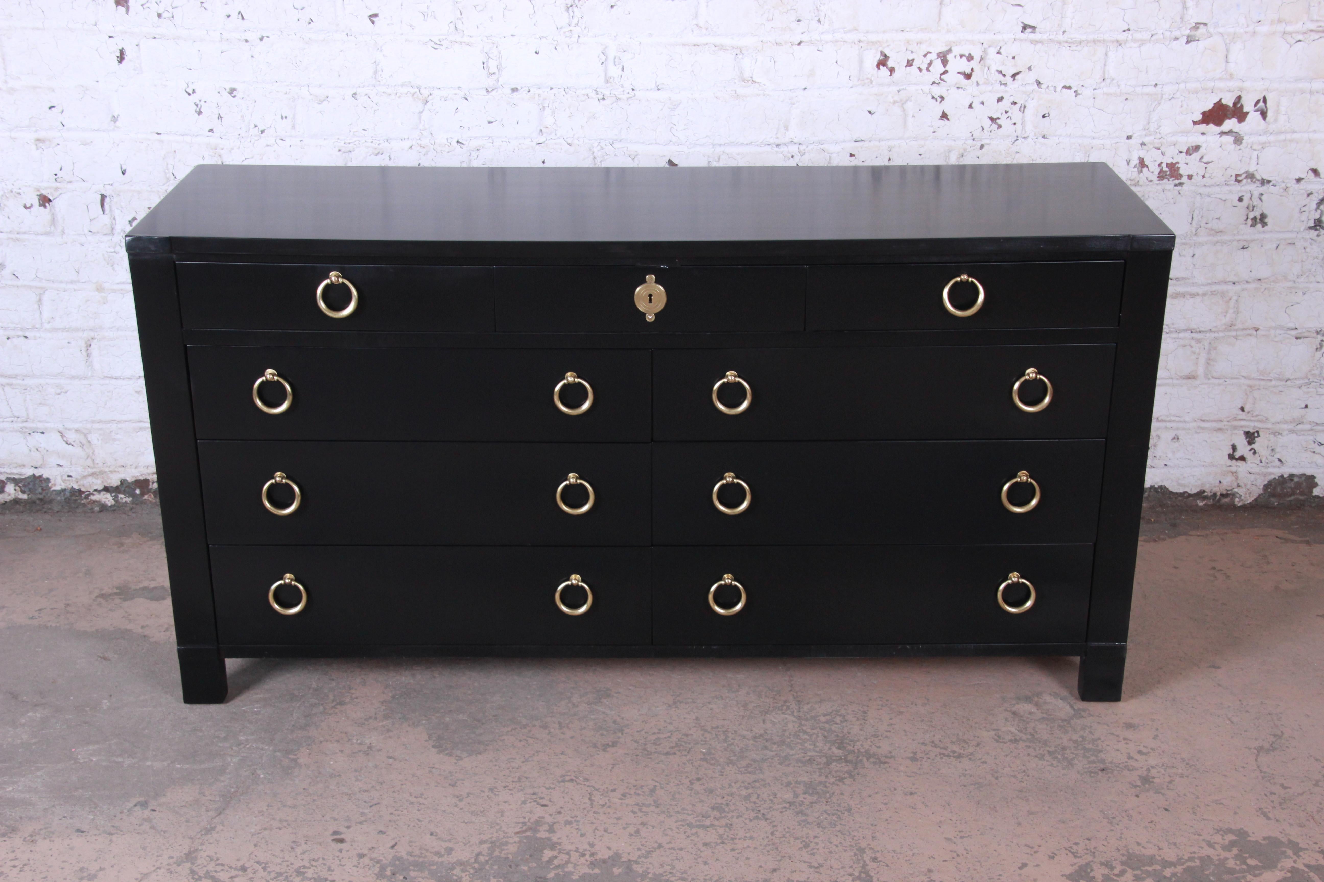 A stunning Hollywood Regency ebonized long dresser by Baker Furniture. The dresser features a beautiful ebonized finish and original solid brass ring drawer pulls. It offers excellent storage, with nine dovetailed drawers. The dresser is well made