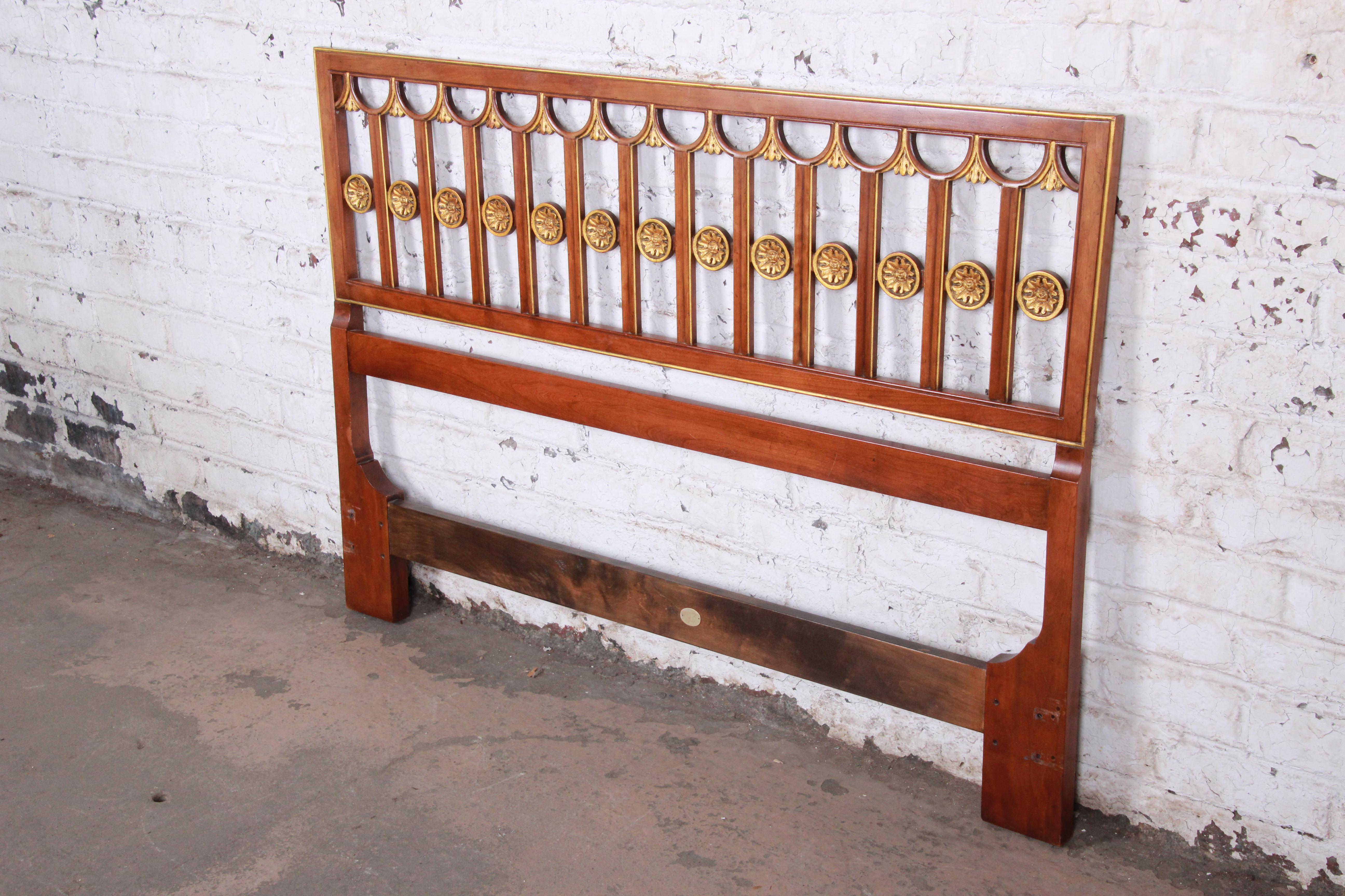 A gorgeous midcentury Hollywood Regency queen size headboard by Baker Furniture. The headboard features solid wood construction with beautiful wood grain and gold gilt floral details and trim. High quality and extremely well made, as expected from