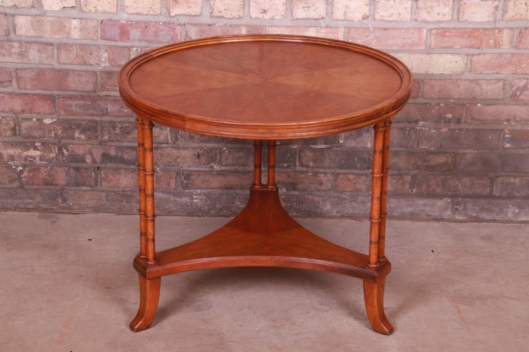 A gorgeous Hollywood Regency tea table or occasional side table

Attributed to Baker Furniture

USA, Circa 1980s

Walnut, with carved faux bamboo legs.

Measures: 26