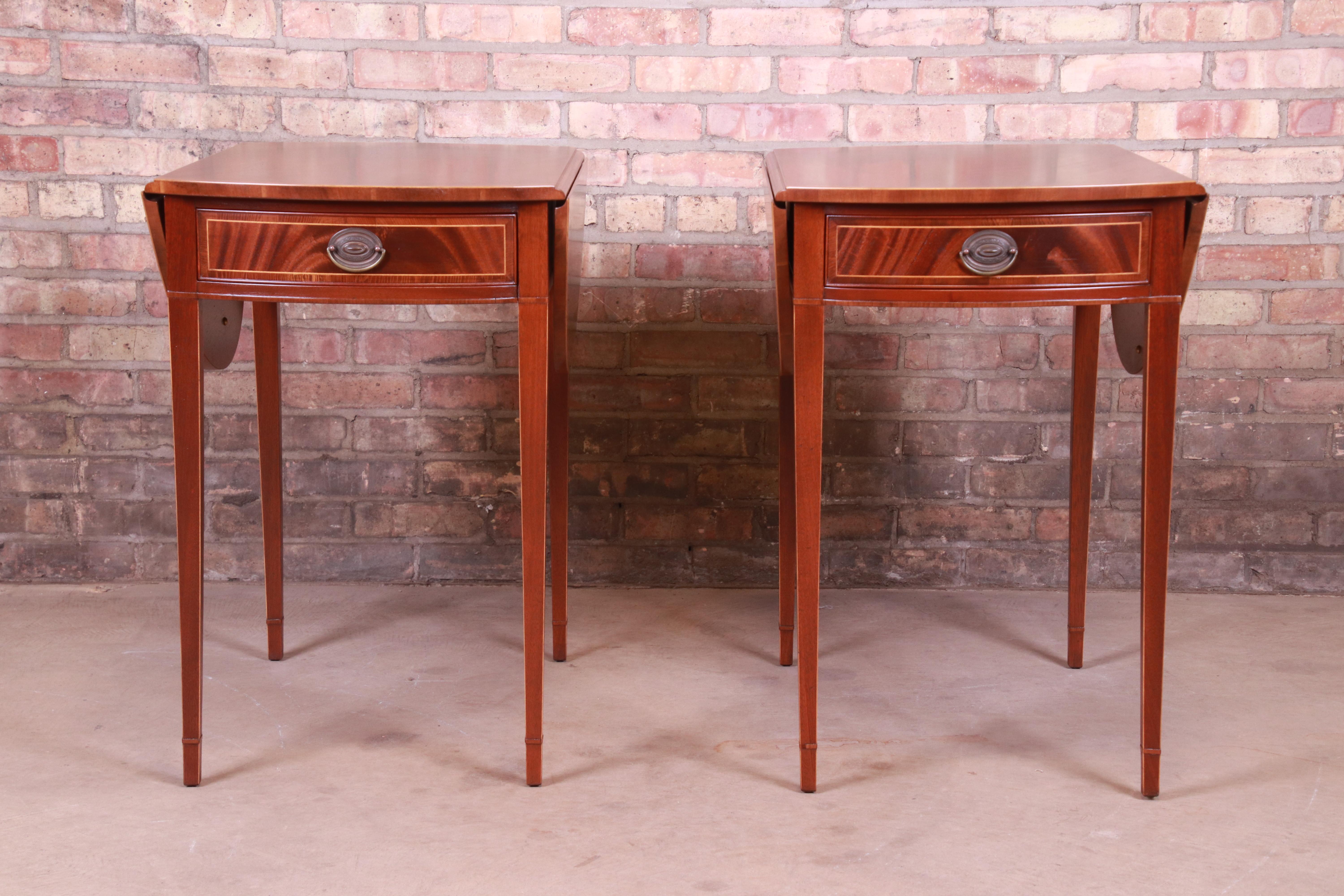 A gorgeous pair of Sheraton style Pembroke nightstands or end tables

By Baker Furniture 

USA, Circa 1940s

Mahogany, with satinwood string inlay and original brass hardware.

Measures: 19.13