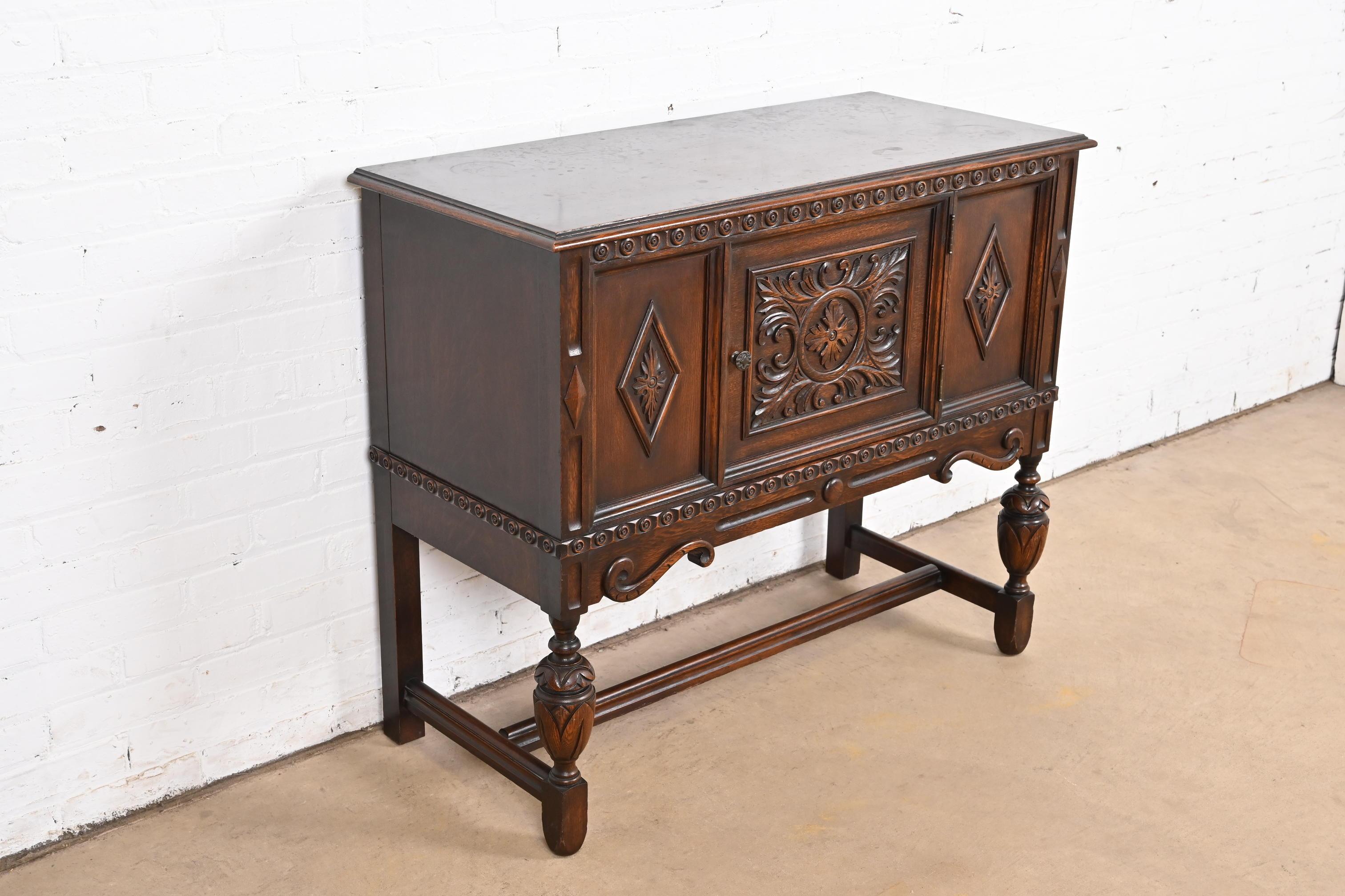 Early 20th Century Baker Furniture Jacobean Carved Oak Sideboard Buffet or Bar Cabinet, Circa 1920s