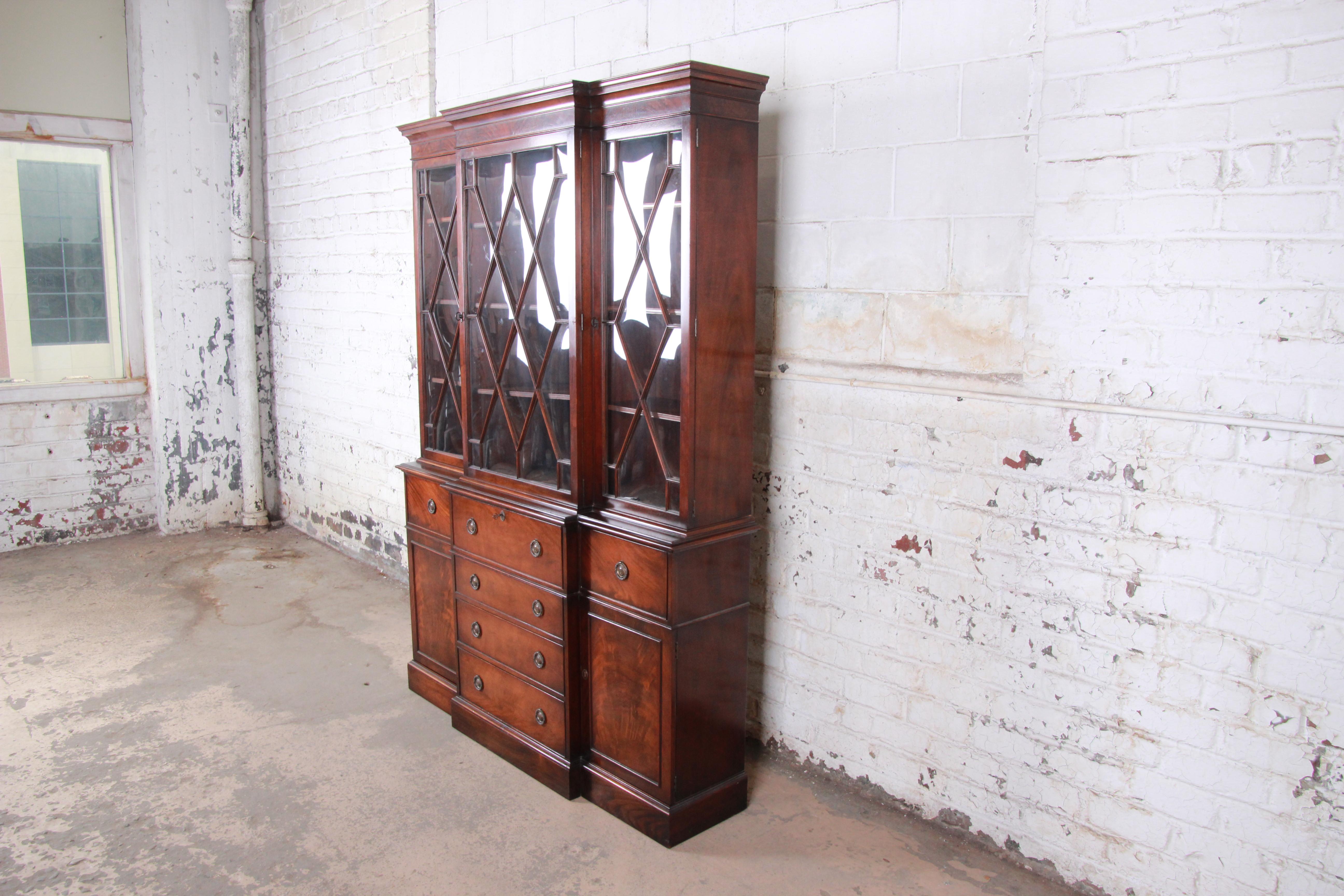 A gorgeous mahogany breakfront display cabinet or bookcase with pull-out leather top secretary desk

By Baker Furniture

USA, circa 1940s

Mahogany + leather + glass + brass

Measures: 58.25