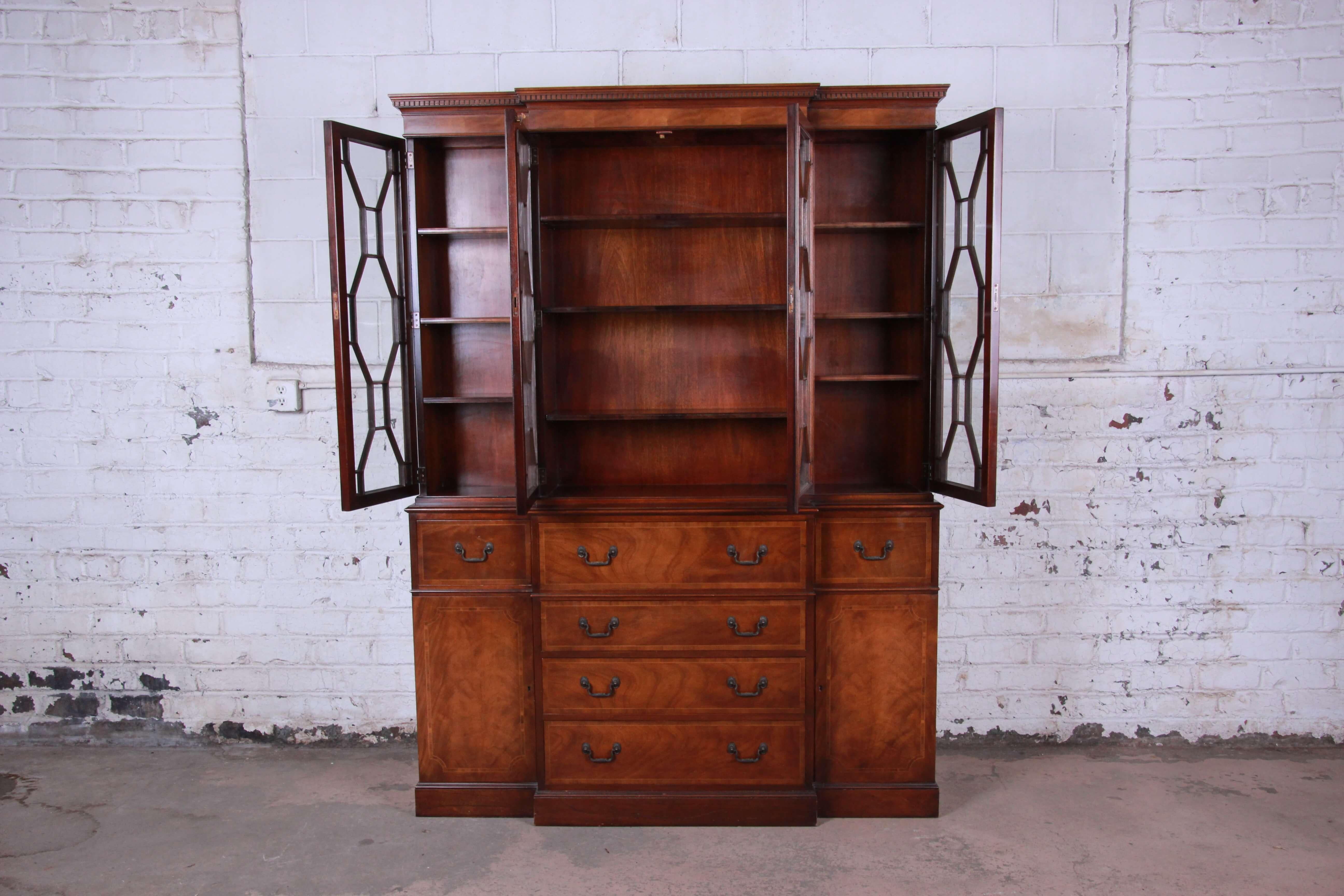 Offering a very nice Baker furniture china cabinet with drop front secretary. The upper portion of the cabinet has two large center cabinet doors that opens up to three adjustable shelves. Each side of the cabinet has another door that opens up to