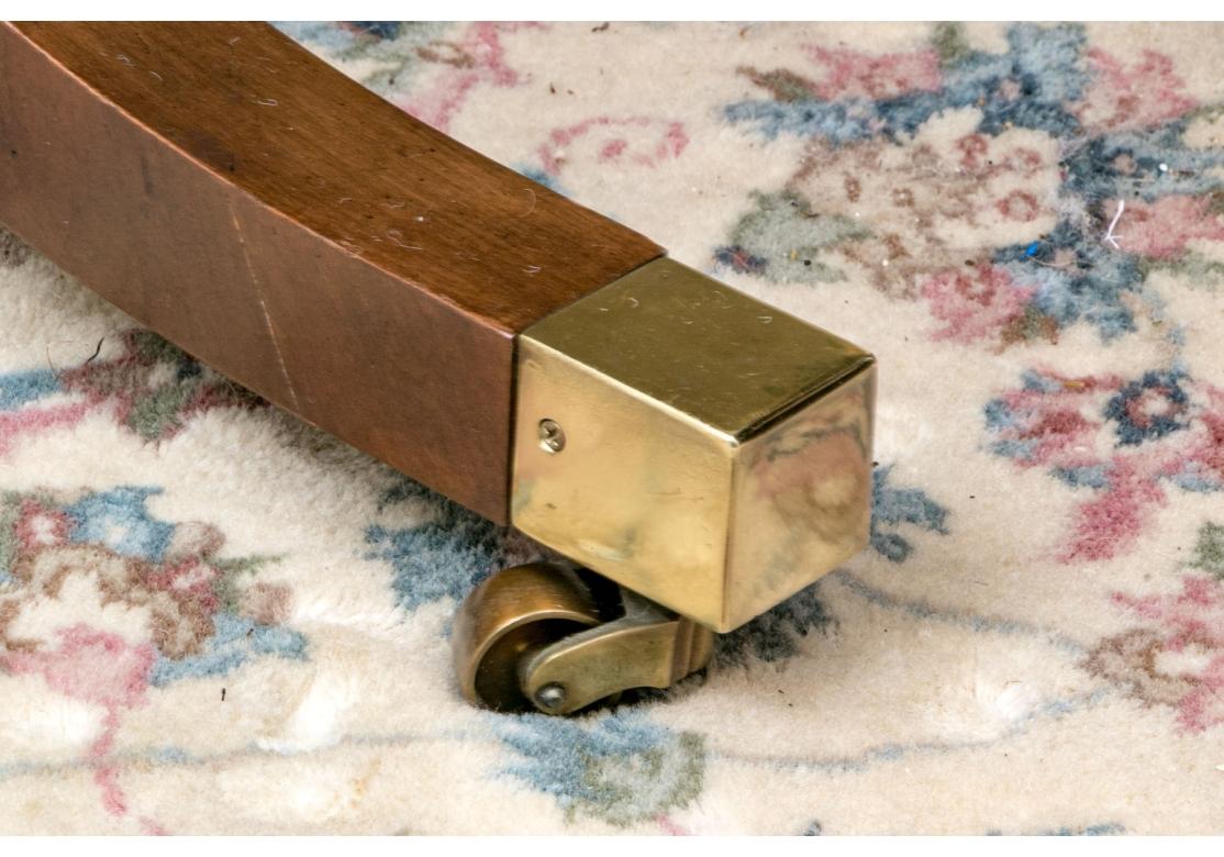 Table de salle à manger à piédestal rond de style géorgien de Baker Furniture, extensible avec deux feuilles et reposant sur des pieds escamotables cachés. Une fois déployés sur les rails métalliques, les pieds tournés peuvent être déposés en place