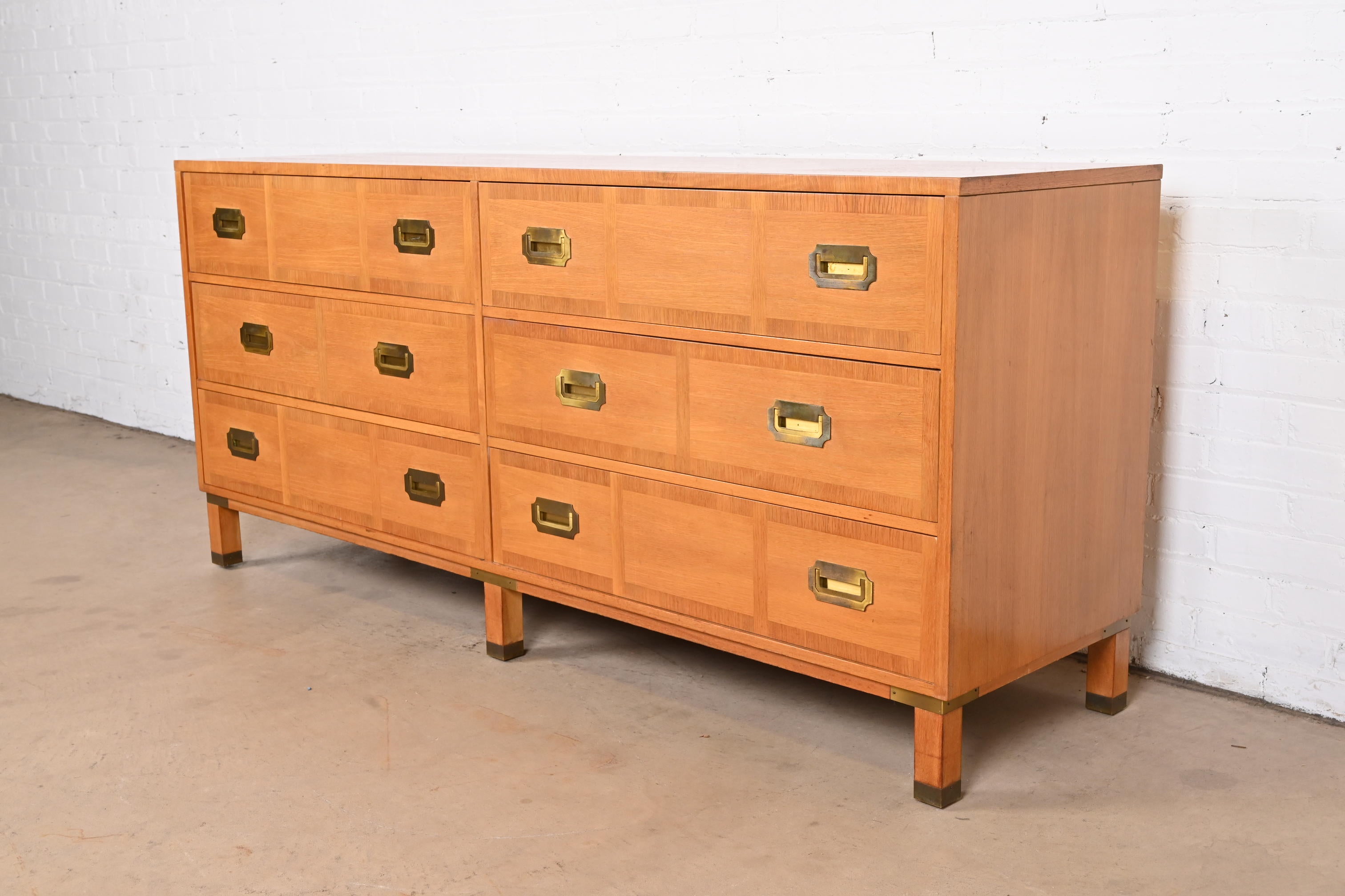 An exceptional mid-century modern Hollywood Regency Campaign style six-drawer dresser or credenza

Produced by Grand Rapids Chair Co. for Baker Furniture, 