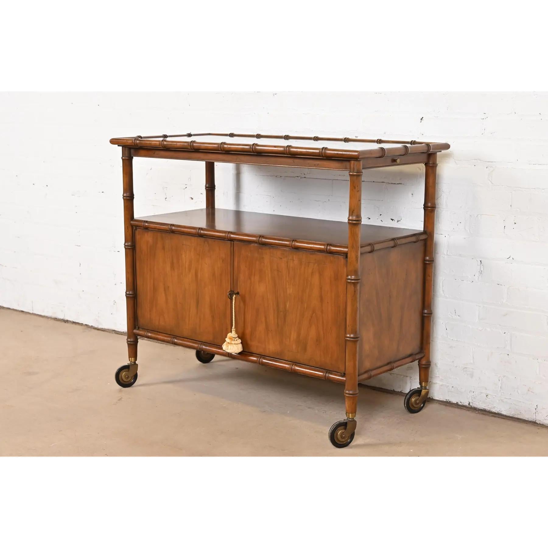A gorgeous Mid-Century Modern Hollywood Regency rolling bar cart server

By Baker Furniture

USA, Circa 1960s

Walnut, with faux bamboo trim. Cabinet locks, and original key is included.

Measures: 38