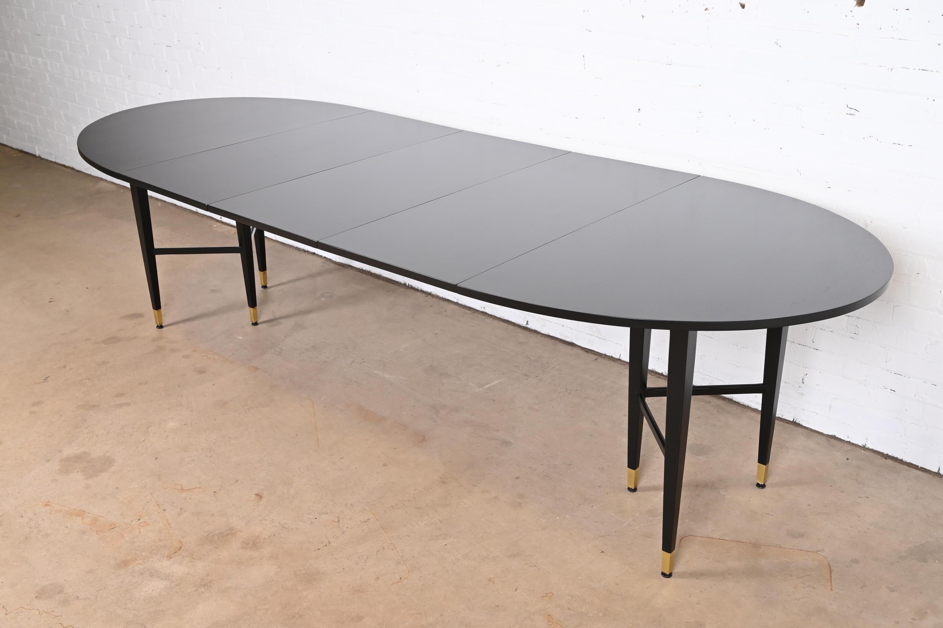 An exceptional Mid-Century Modern extension dining table

In the style of Paul McCobb

By Baker Furniture

USA, 1960s

Black lacquered walnut, with brass-capped feet.

Measures: 56
