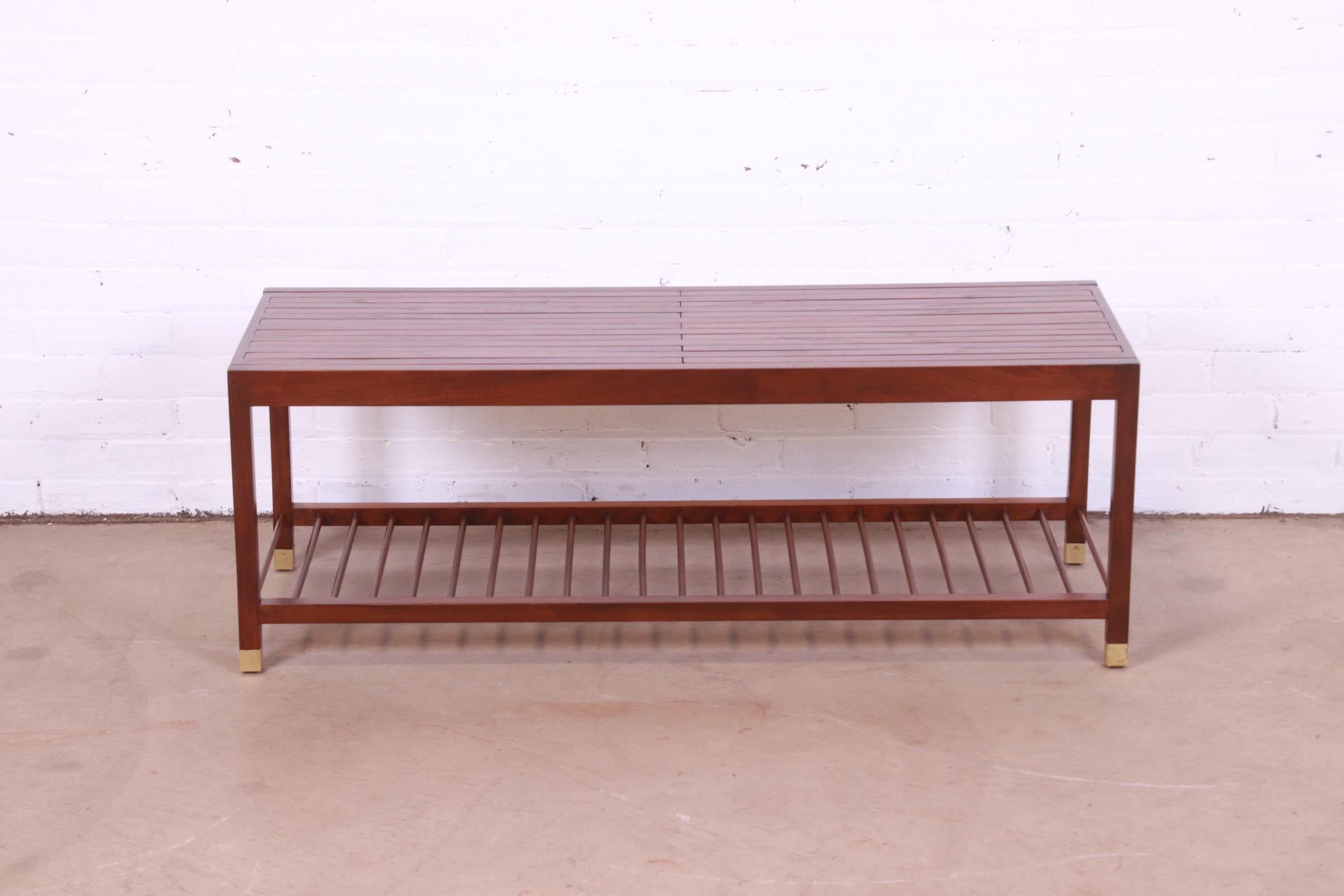 A sleek and stylish Mid-Century Modern slatted expandable bench or coffee table

By Baker Furniture

USA, Circa 1960s

Teak, with brass-capped feet.

Measures: 48