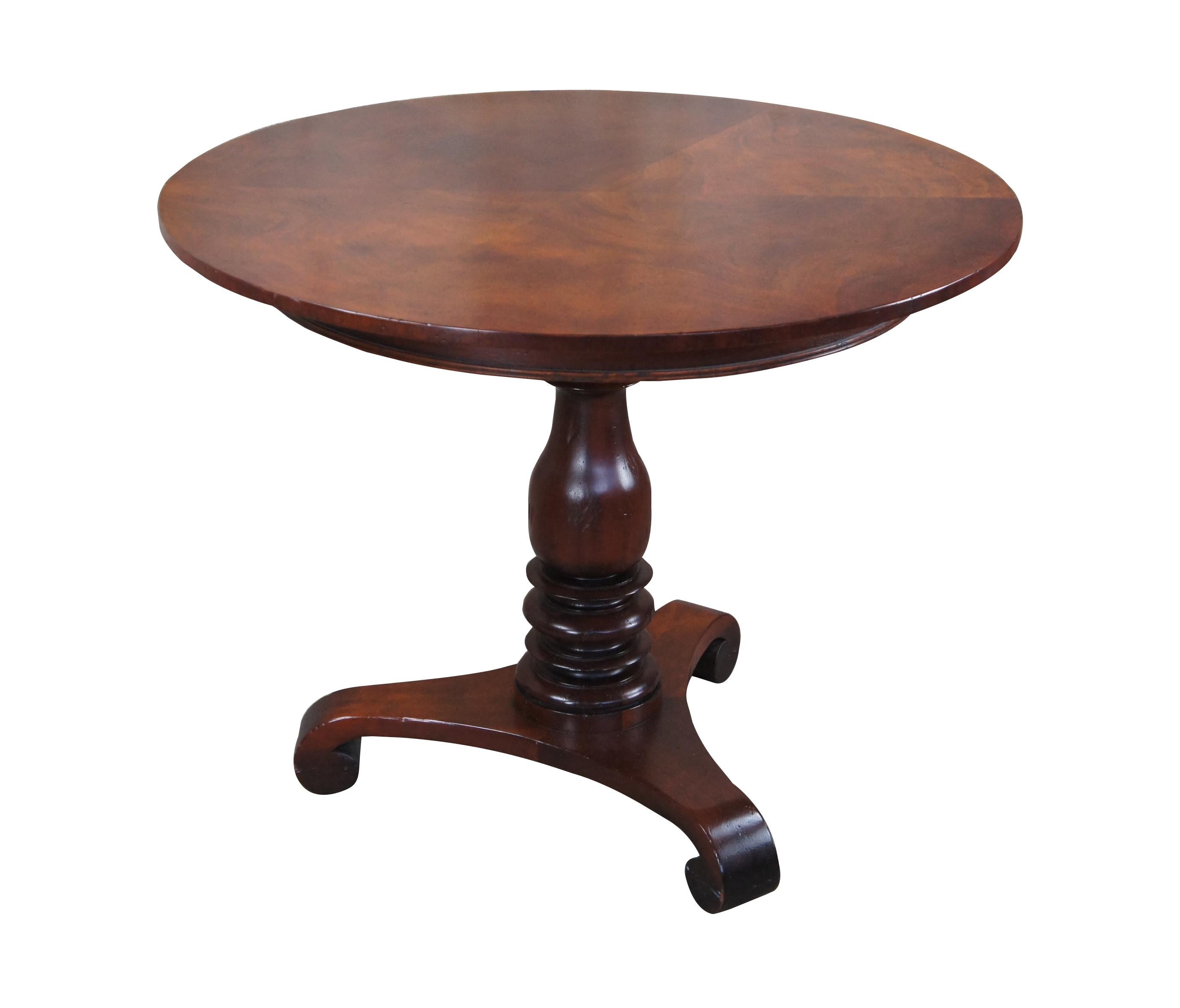 Vintage Baker Furniture Milling Road Collection American Empire style center table, circa 1980s.  Made of mahogany featuring round form with pie matchbook top, turned baluster column and scrolled tri foot base. 

Dimensions:
36