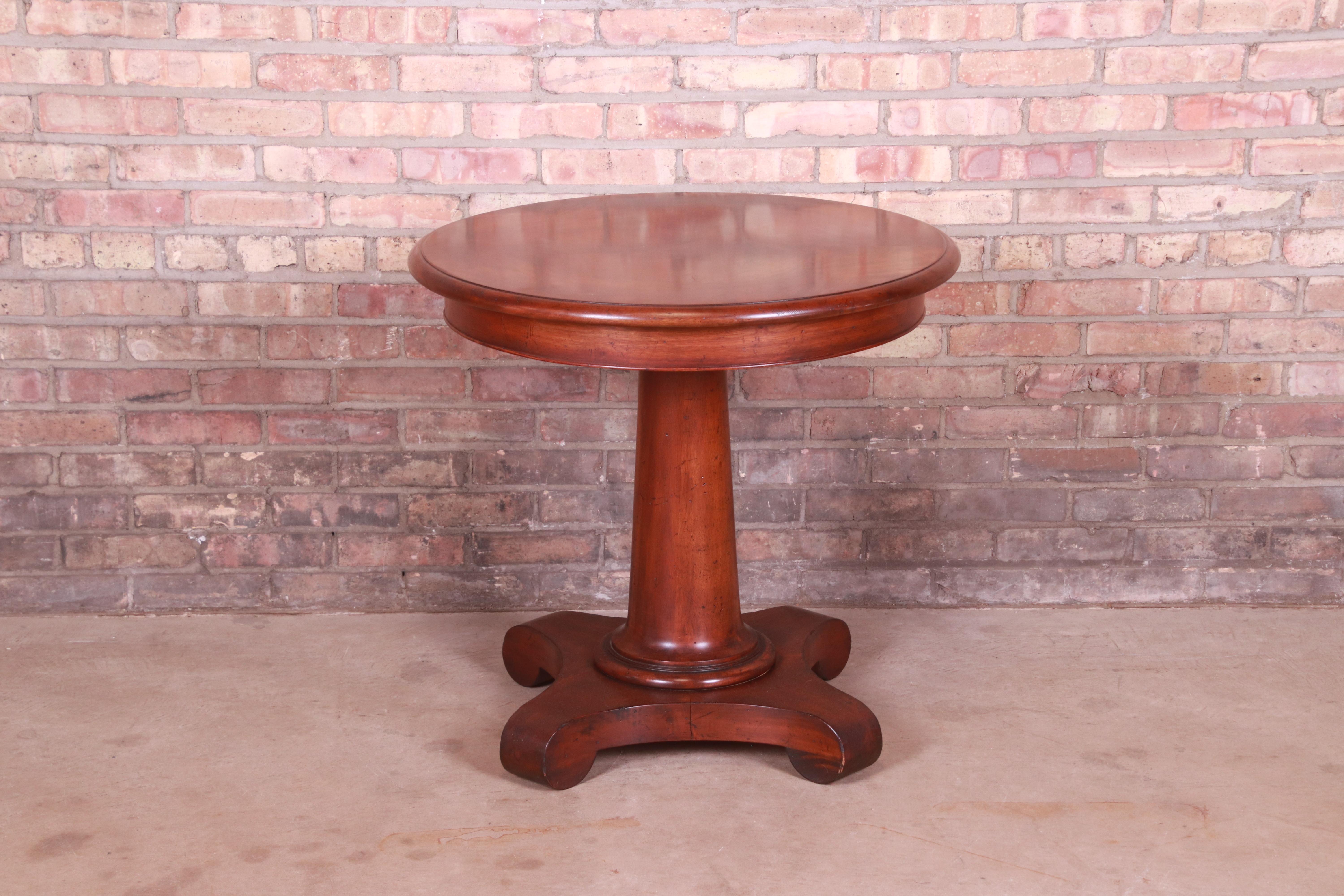A gorgeous French Empire style carved mahogany pedestal tea table or occasional side table

By Baker Furniture 