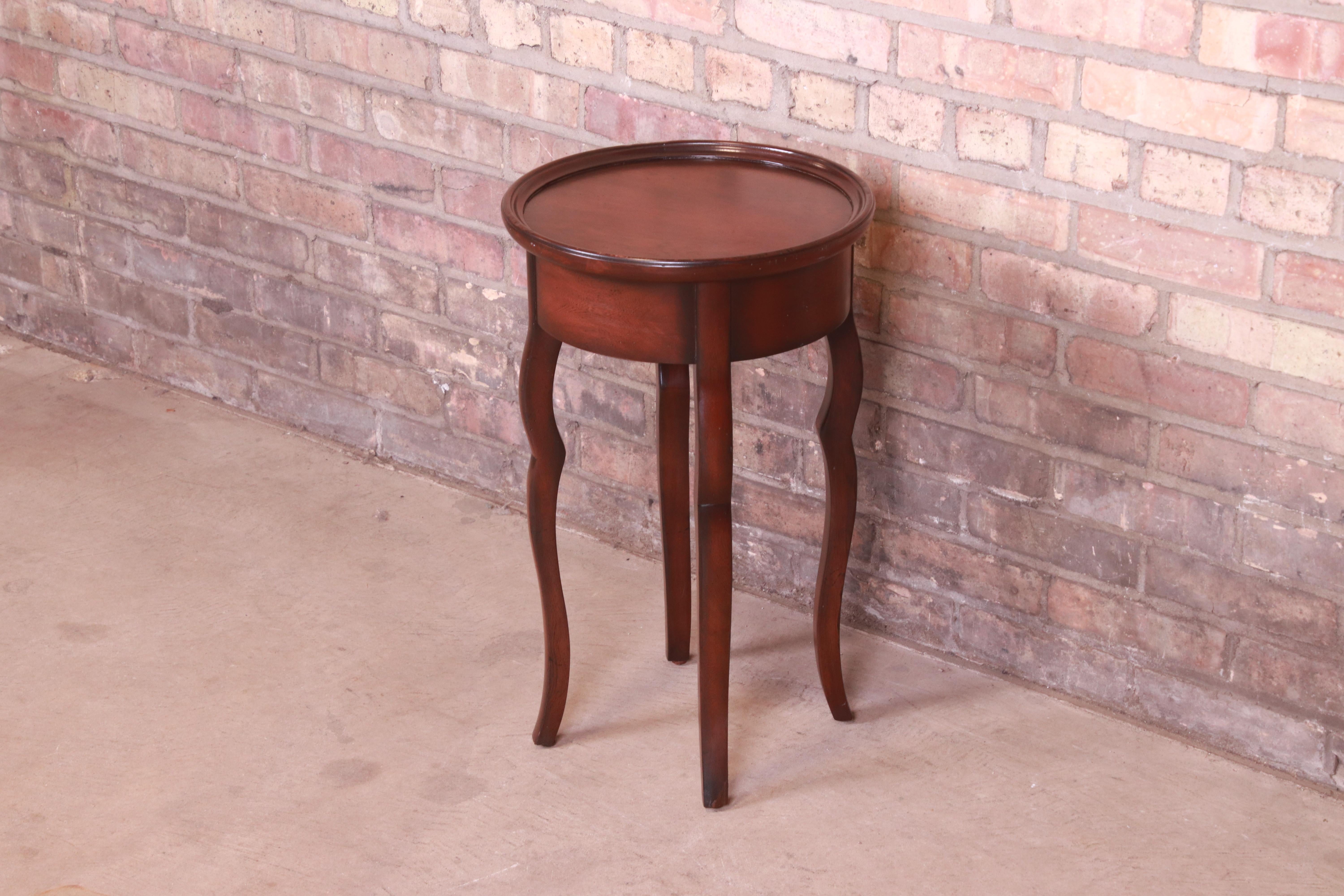 A gorgeous French Provincial carved mahogany tea table or occasional side table

By Baker Furniture 