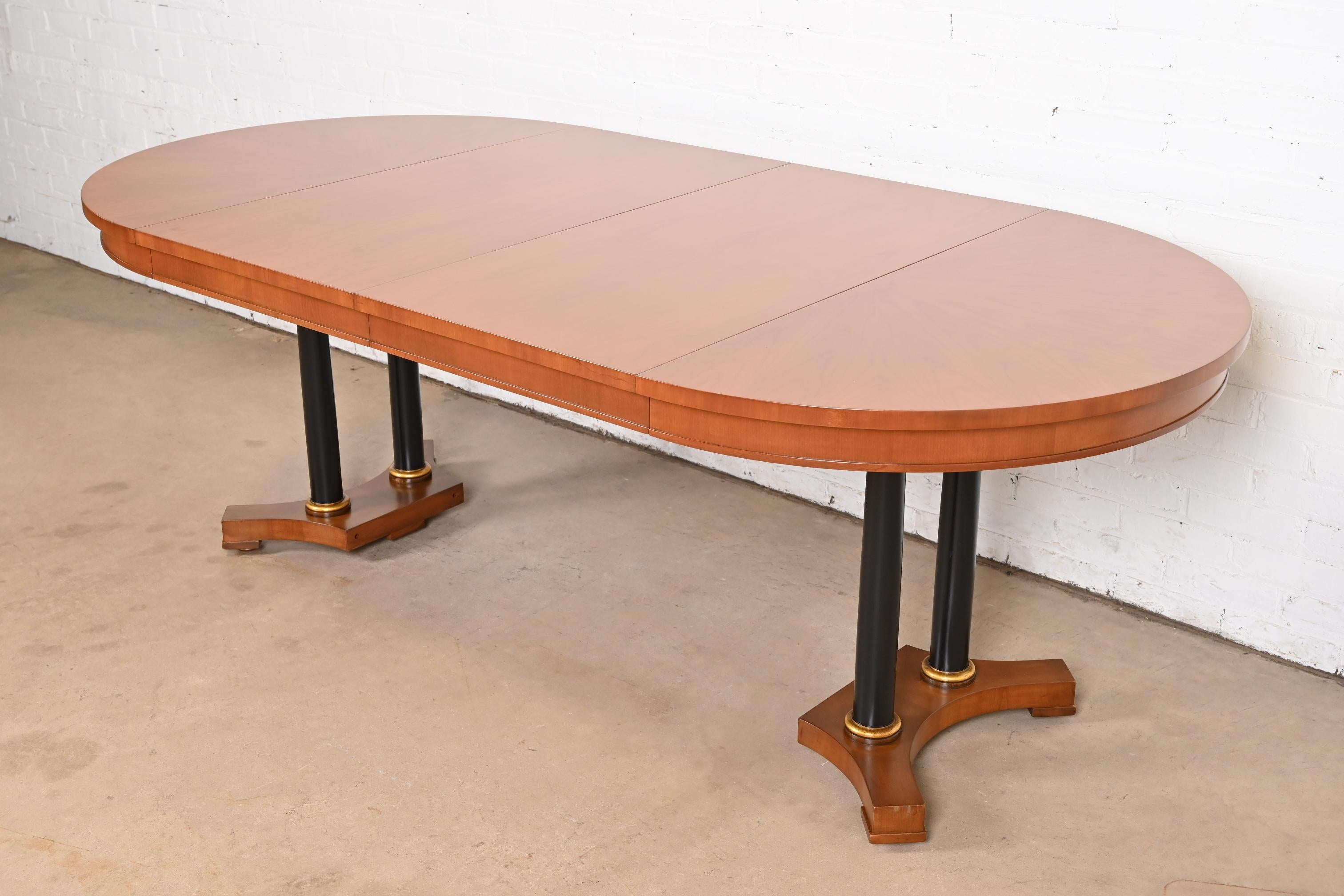 Una excepcional mesa de comedor extensible de pedestal partido de estilo Neoclásico, Imperio o Biedermeier

Por Baker Furniture

EE.UU., alrededor de 1960

Preciosa madera de cerezo a juego con los libros, con pedestal de columna ebonizado y