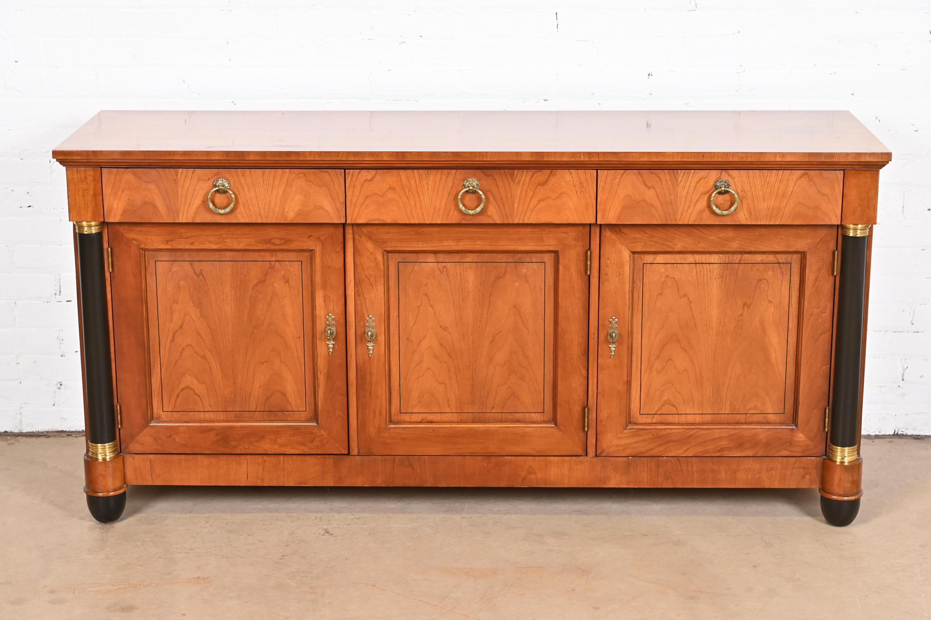 A gorgeous French Empire or Neoclassical style sideboard, credenza, or bar cabinet

By Baker Furniture

USA, circa 1980s

Carved cherry wood, with ebonized columns and feet, and original brass hardware.

Measures: 66