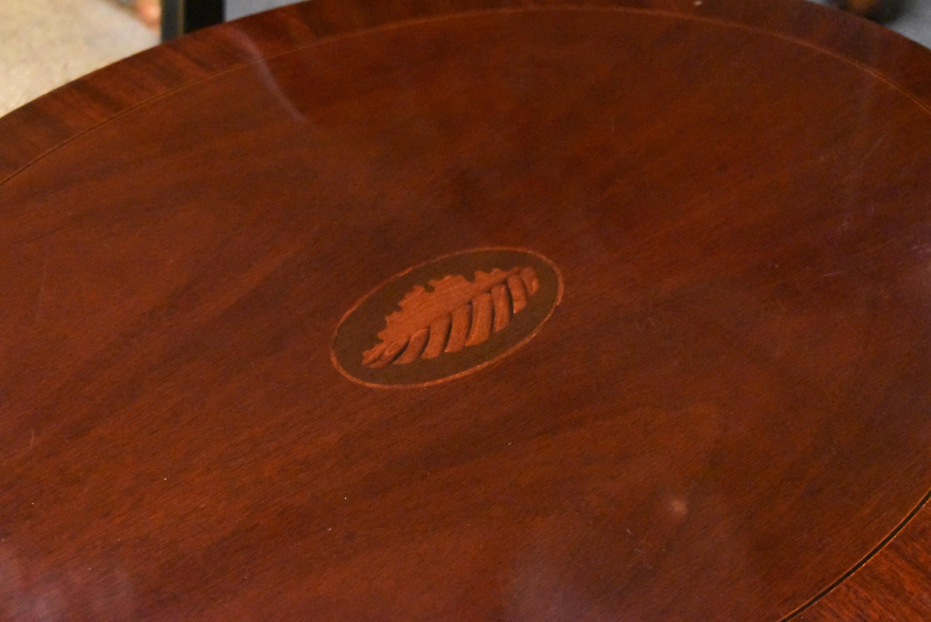 Baker Furniture oval nesting tables with shell fruitwood and mahogany inlay. Smaller table has bowed front and back. Very slight wear. Oval table measures 17