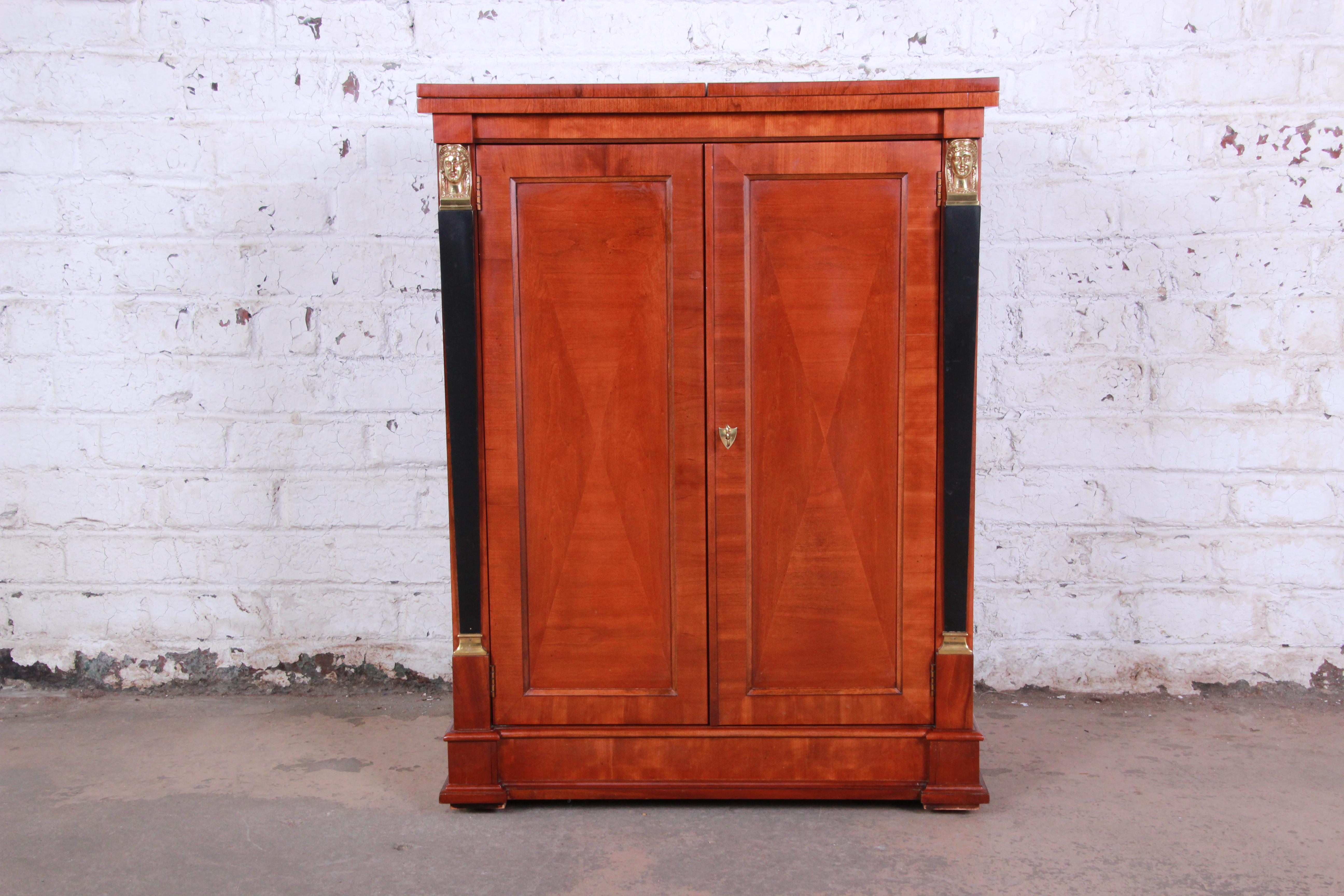 An exceptional Neoclassical style rolling bar cart or server from the Palladian Collection by Baker Furniture. Inspired by the neoclassic styles of 16th century architect Palladio, the cabinet features gorgeous cherry wood grain with ebonized