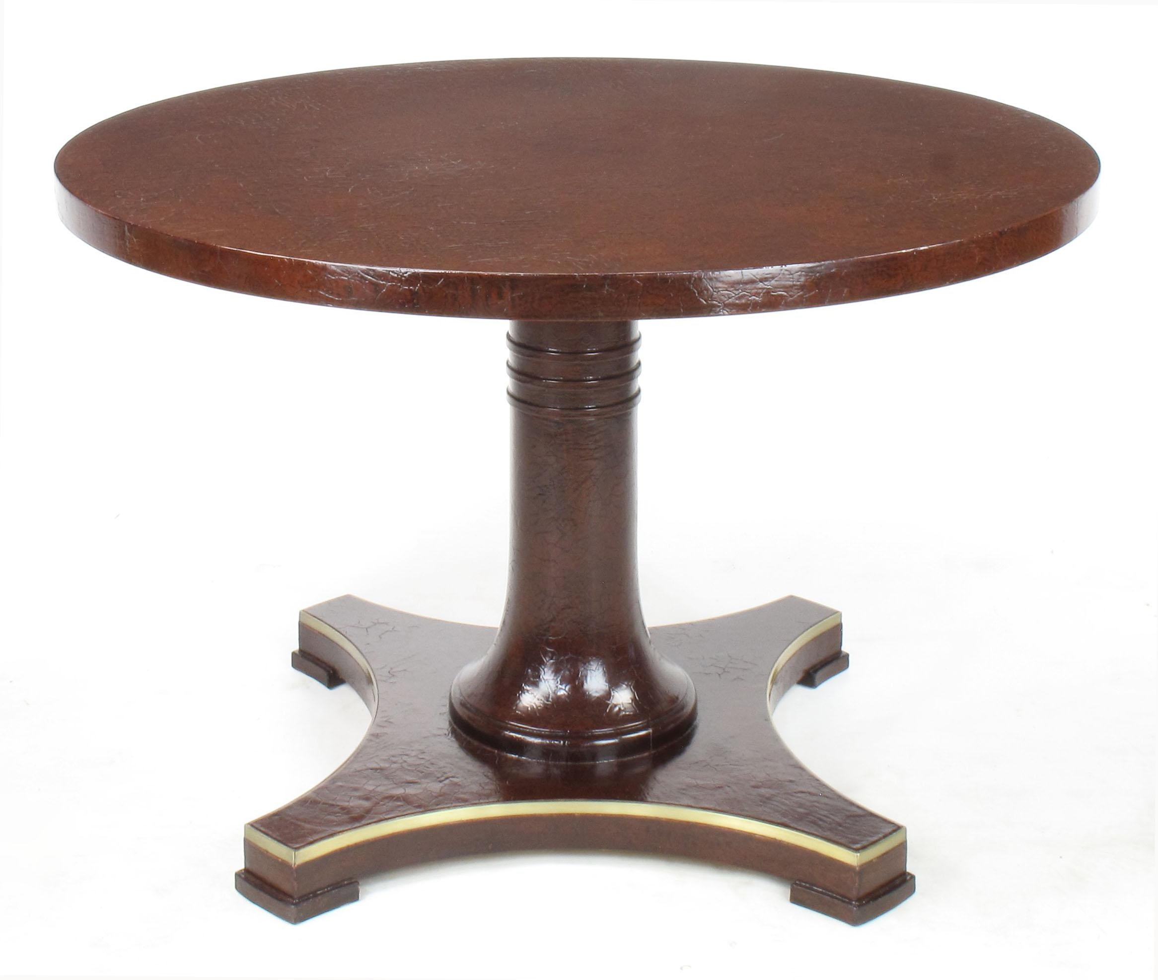 Baker Furniture oxblood lacquer pedestal games table with craquelure finish. The finish is offset by a black glaze that really makes the crackle finish pop. The base is a brass detailed reverse quatrefoil plinth and the center post features three
