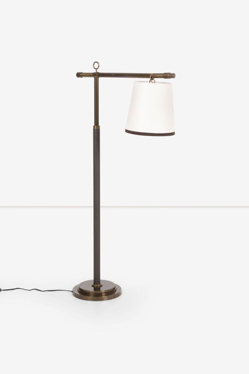 Baker Furniture Peony reading lamp designed by Laura Kirar. Cantilevered Bronze post with stem wrapped in brown leather and a white overhanging shade with brown trim and greek key on off switch. “The Peony Lighting Series draws its inspiration from
