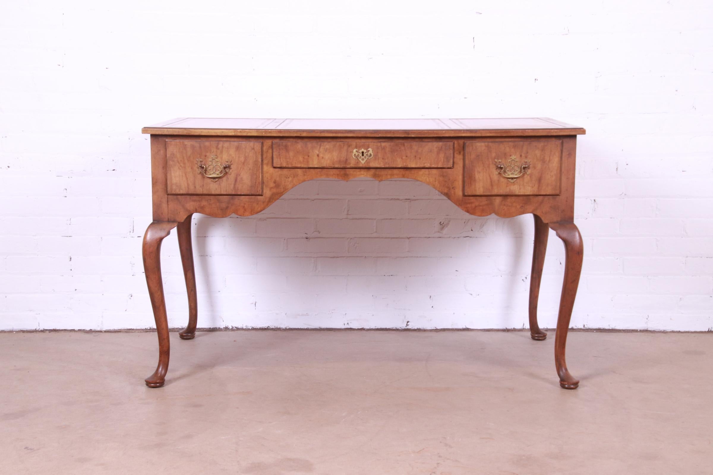 A gorgeous Queen Anne style writing desk

By Baker Furniture

USA, Mid-20th Century

Burled walnut, with inset embossed leather top and original brass hardware.

Measures: 49