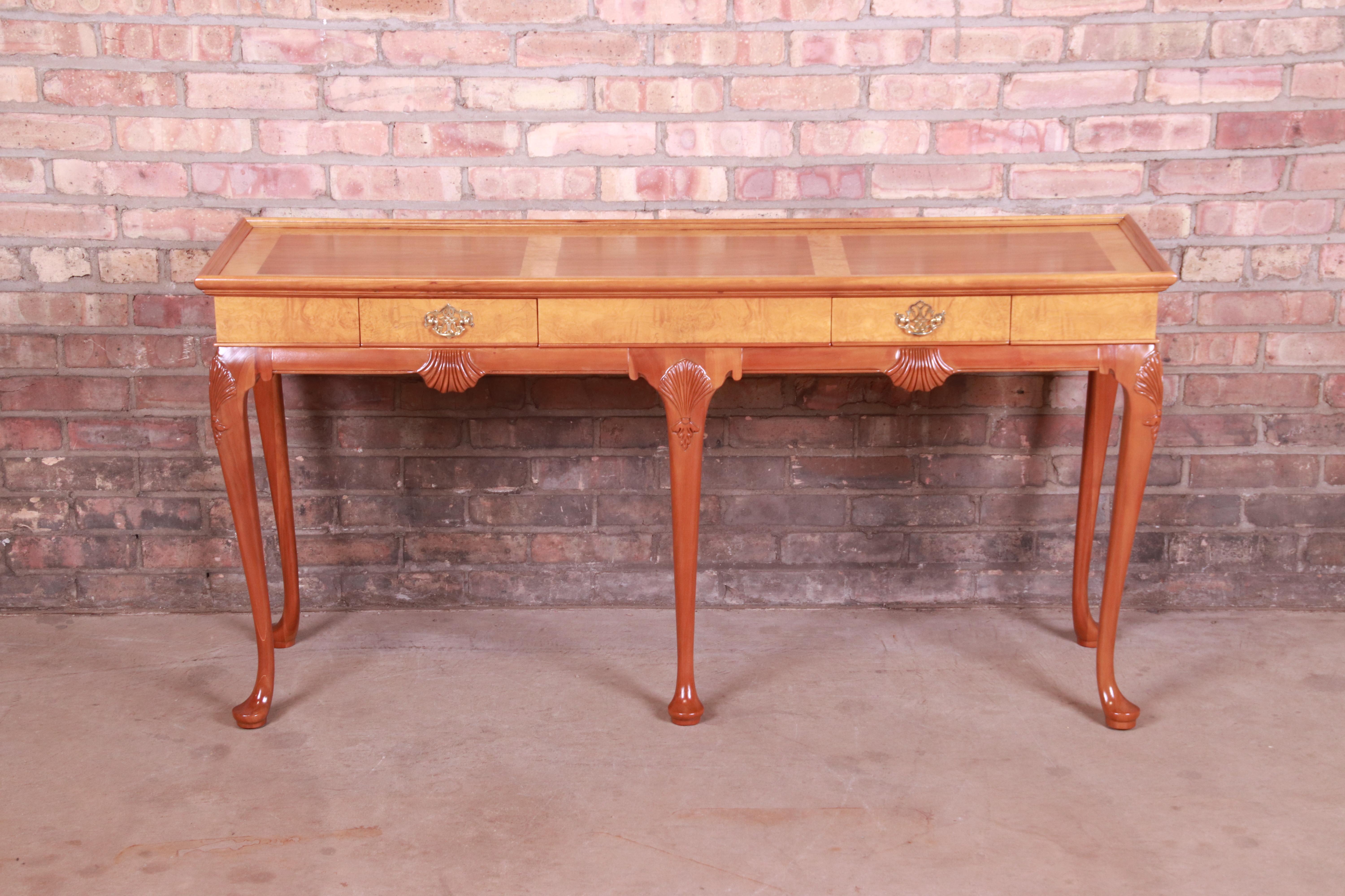 A gorgeous Queen Anne style console table or sofa table

By Baker Furniture

USA, Circa 1980s

Carved cherry and burl woods with shell motif, cabriole legs, and original brass hardware.

Measures: 54