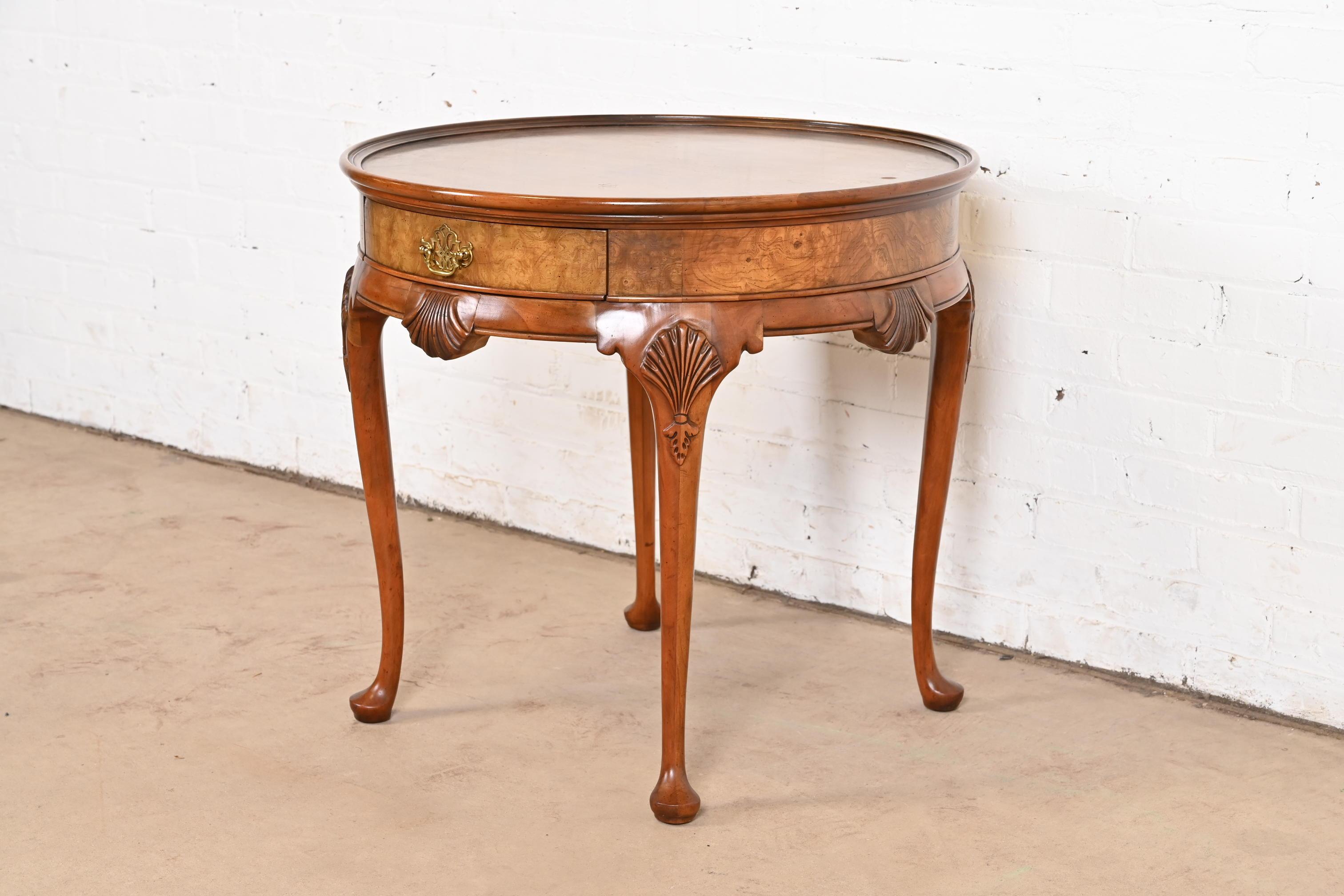 Ein prächtiger Beistelltisch, Nachttisch oder Teetisch im Queen-Anne-Stil

Von Baker Furniture

USA, ca. 1960er Jahre

Geschnitztes Kirschholz, mit genopptem Nussbaumband und originalen Messingbeschlägen.

Maße: 26 