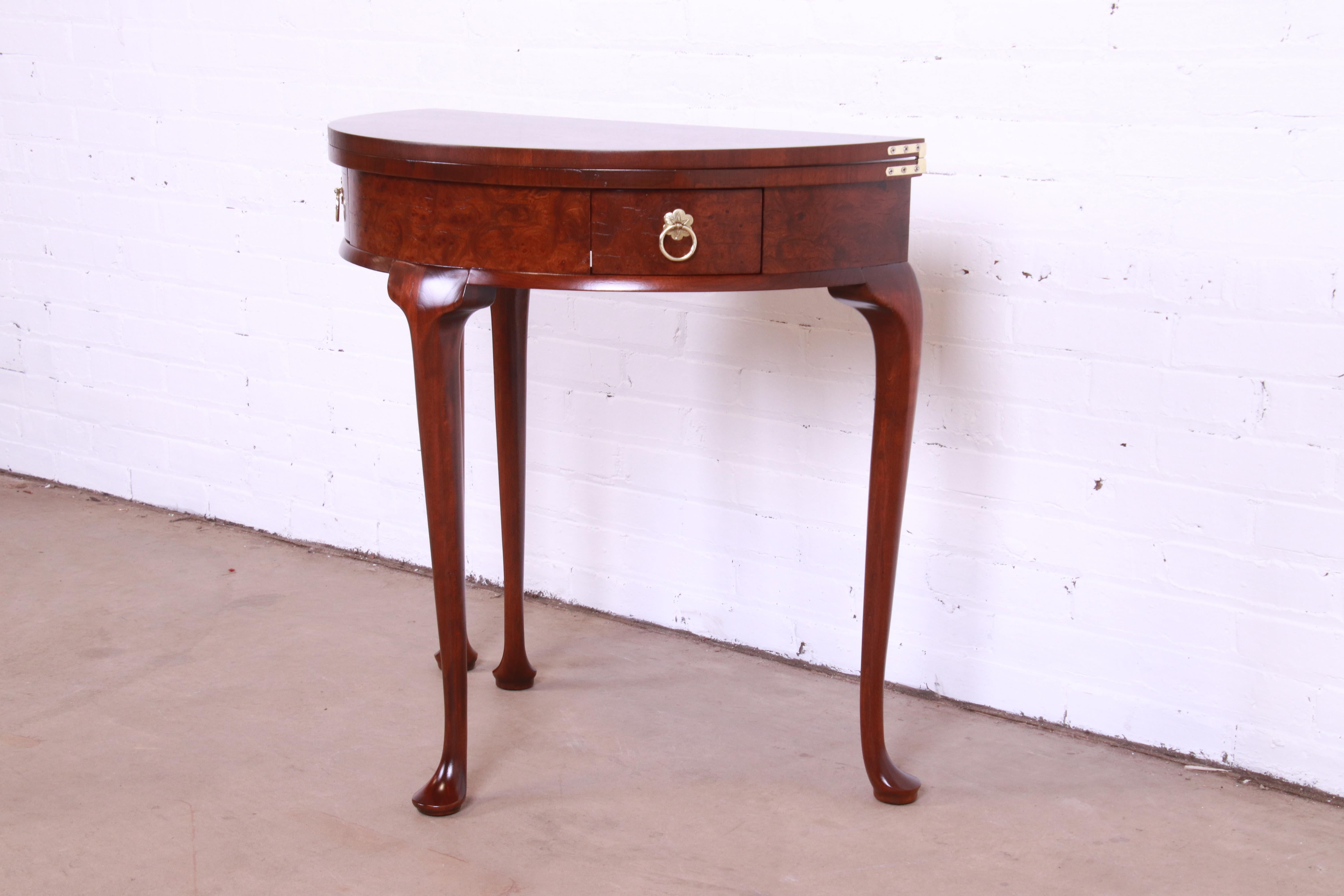 A gorgeous Queen Anne style demilune console, entry table, or tea table

By Baker Furniture

USA, Circa 1980s

Banded mahogany, with burled walnut front and original brass hardware.

Measures: 30