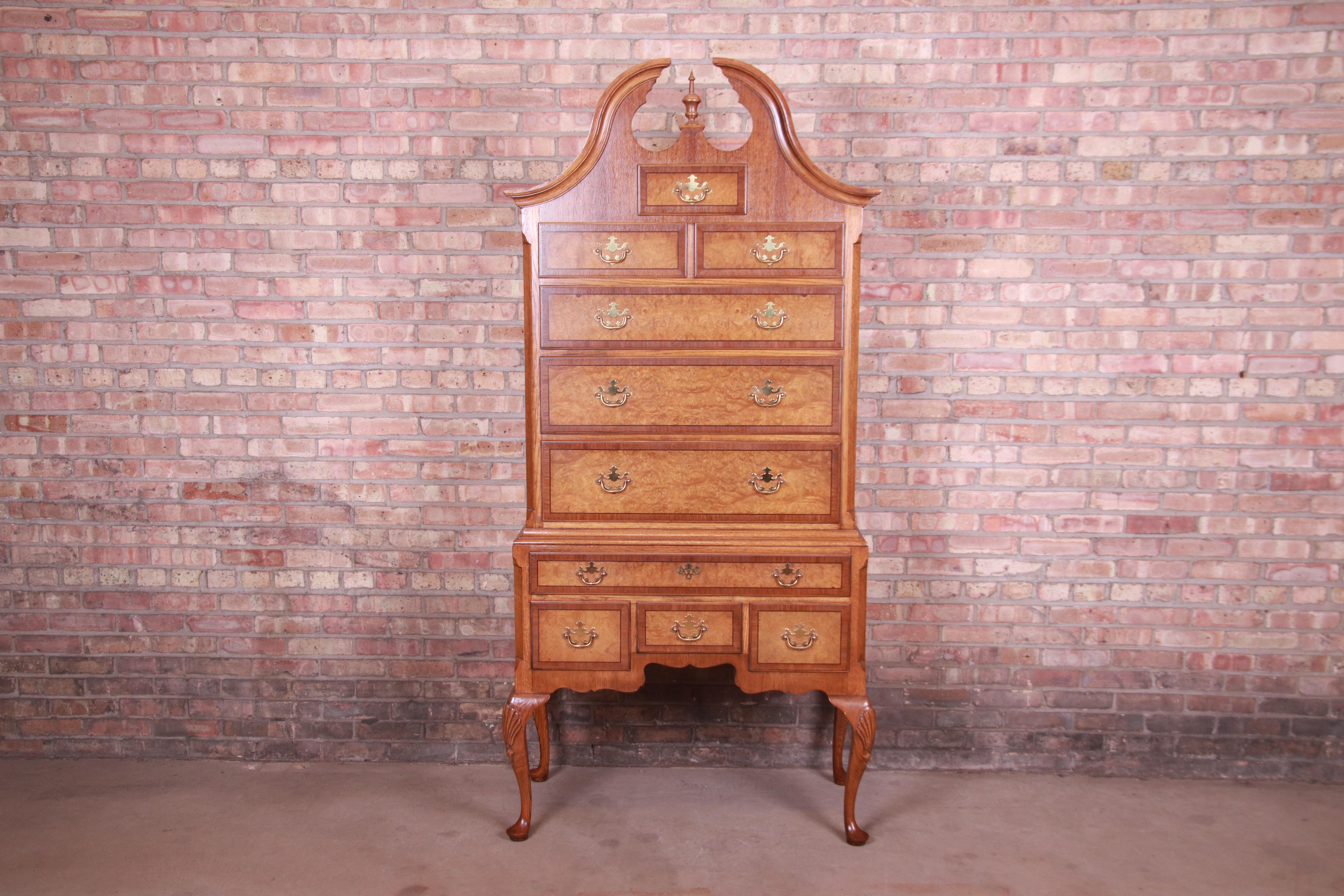 A gorgeous Queen Anne style ten-drawer highboy chest of drawers

By Baker Furniture

USA, Circa 1980s

Carved oak, with burled walnut drawer fronts and original brass hardware.

Measures: 39.5