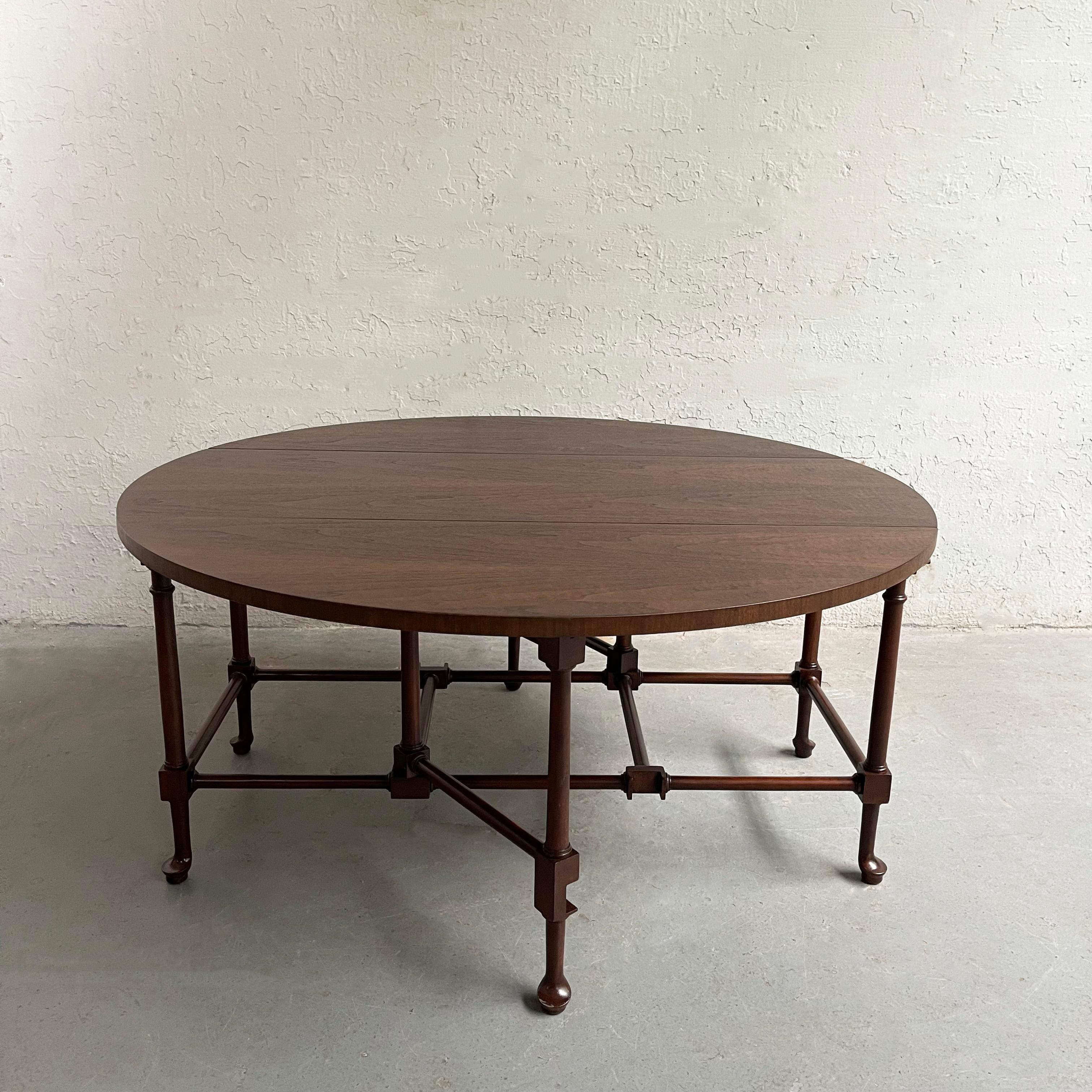 Midcentury, Queen Anne style, walnut, gate-fold, drop leaf, coffee table by Baker Furniture is 38 inches diameter when fully opened. It can be used as a demi-lune table at 27 inches or folded to 16 inches with both leaves down.