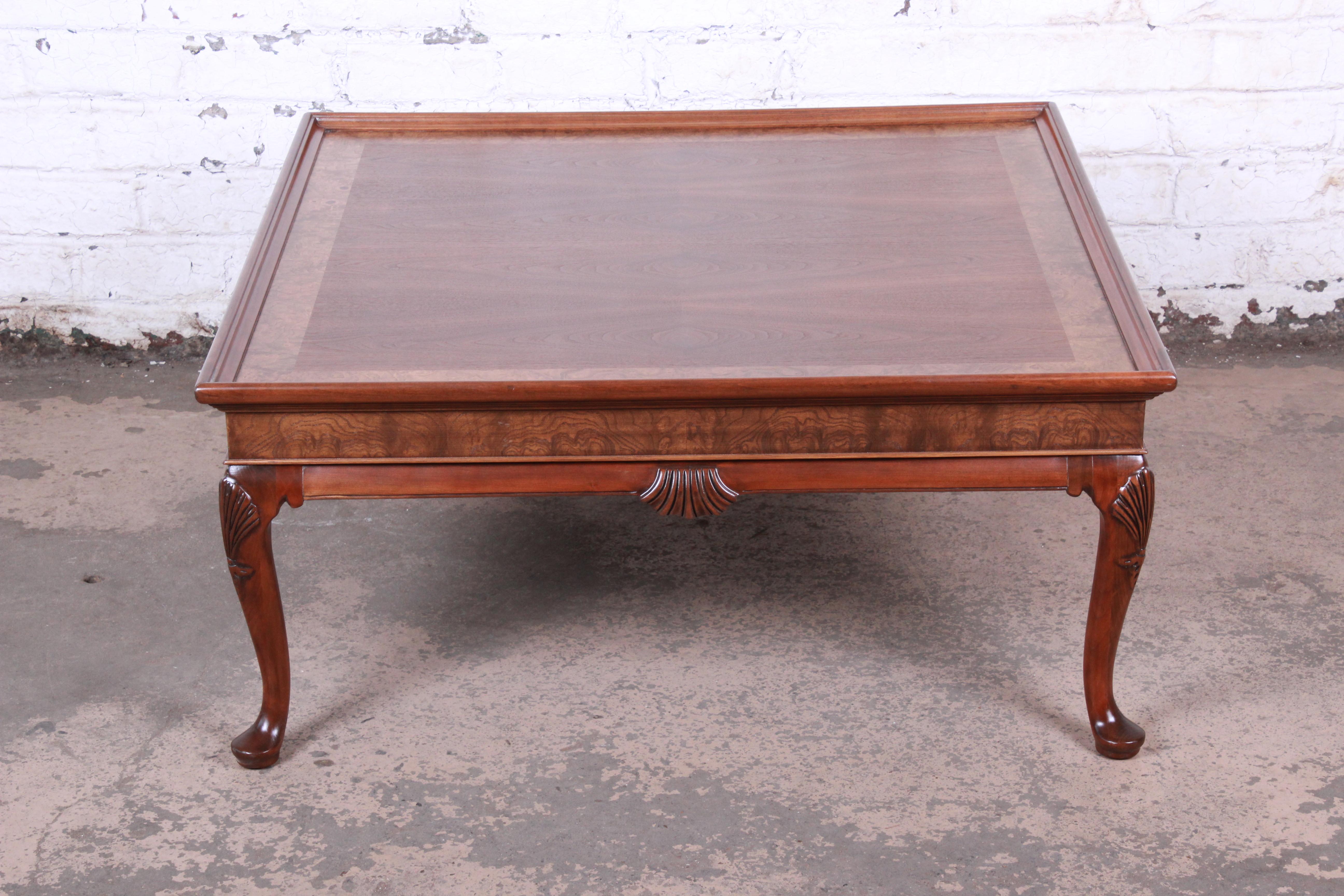 A gorgeous Queen Anne style large coffee table

By Baker Furniture

USA, circa 1980s

Bookmatched walnut + olive ash burl banding + carved cabriole legs with shell motif

Measures: 40