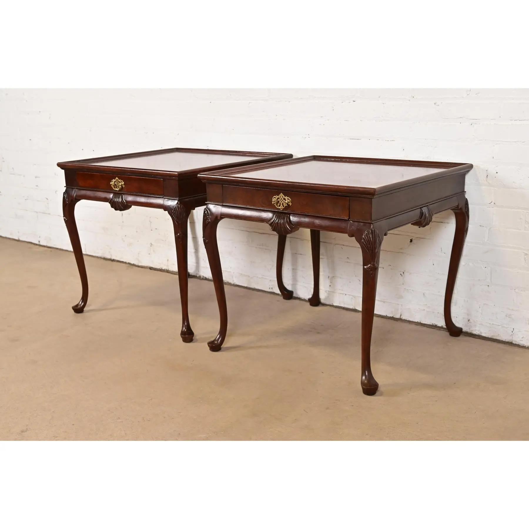 A gorgeous pair of Queen Anne or Chippendale style nightstands or side tables

By Baker Furniture

USA, Circa 1980s

Book-matched walnut top, with burl wood banding, carved cabriole legs with shell motif, and original brass hardware.

Measures: 26