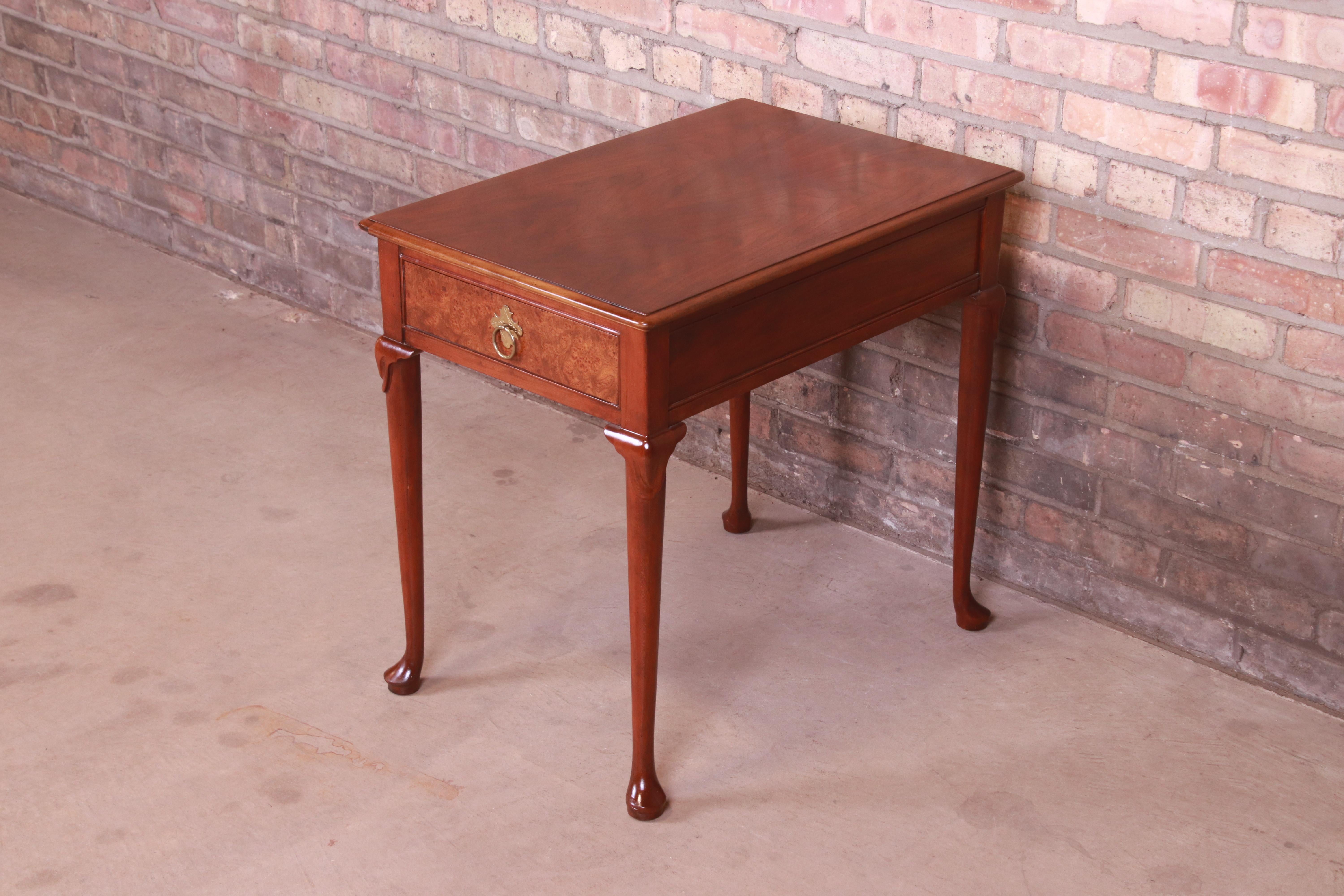 A gorgeous Queen Anne style occasional side table or nightstand

By Baker Furniture

USA, late 20th century

Walnut, with burl wood drawer front and original brass hardware.

Measures: 18