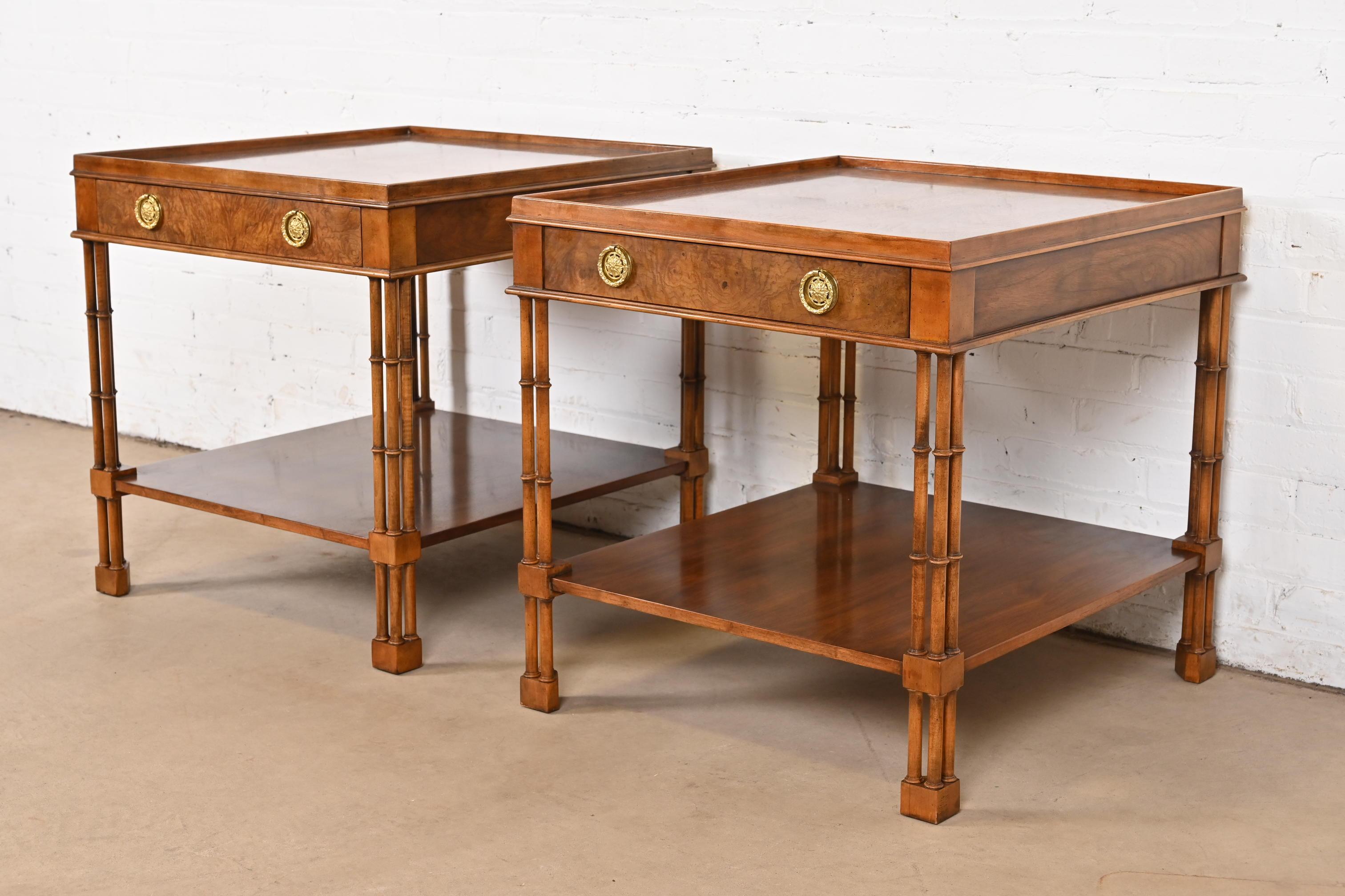 A gorgeous pair of Regency style nightstands, tea tables, or occasional side tables

By Baker Furniture

USA, Circa 1980s

Burled walnut, with gorgeous book-matched top, faux bamboo legs, and original brass hardware.

Each measures: 24.88
