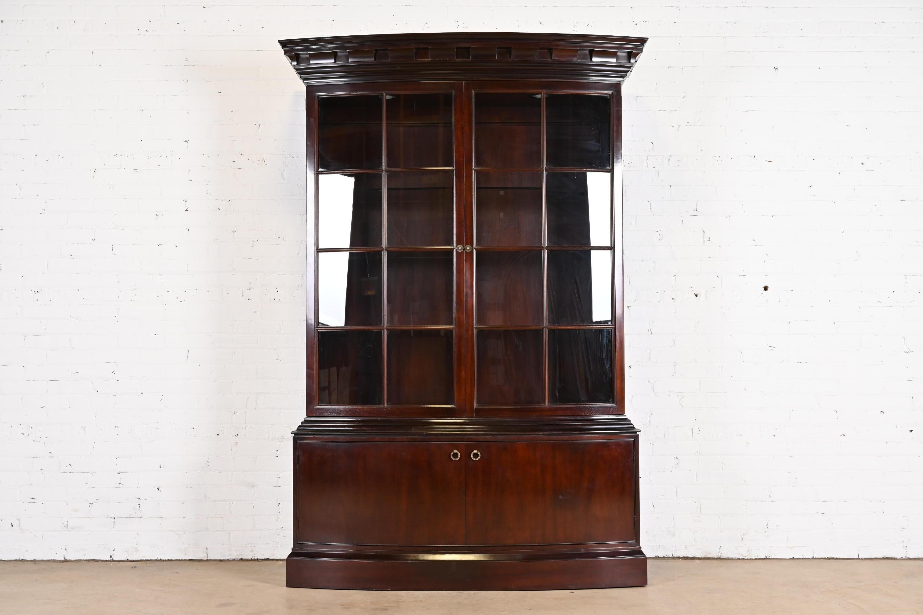 A gorgeous modern Regency or Georgian style bow front lighted breakfront bookcase or dining cabinet

By Baker Furniture

USA, Late 20th Century

Carved mahogany, with mullioned glass front doors, and original brass hardware. Lights have been tested