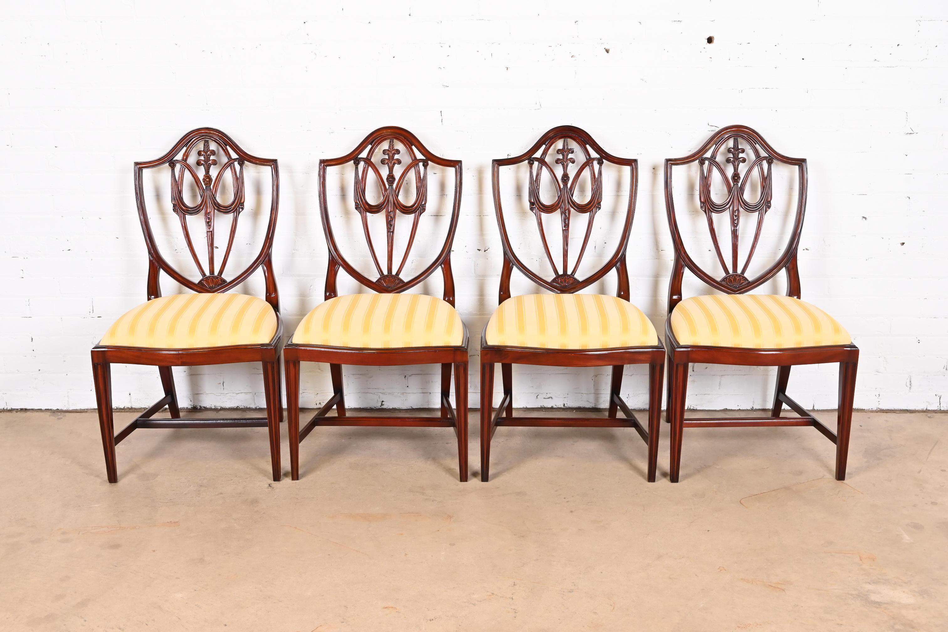 A gorgeous set of four Regency or Georgian style shield back dining chairs

By Baker Furniture

USA, Circa 1980s

Carved mahogany, with upholstered seats.

Measures: 21