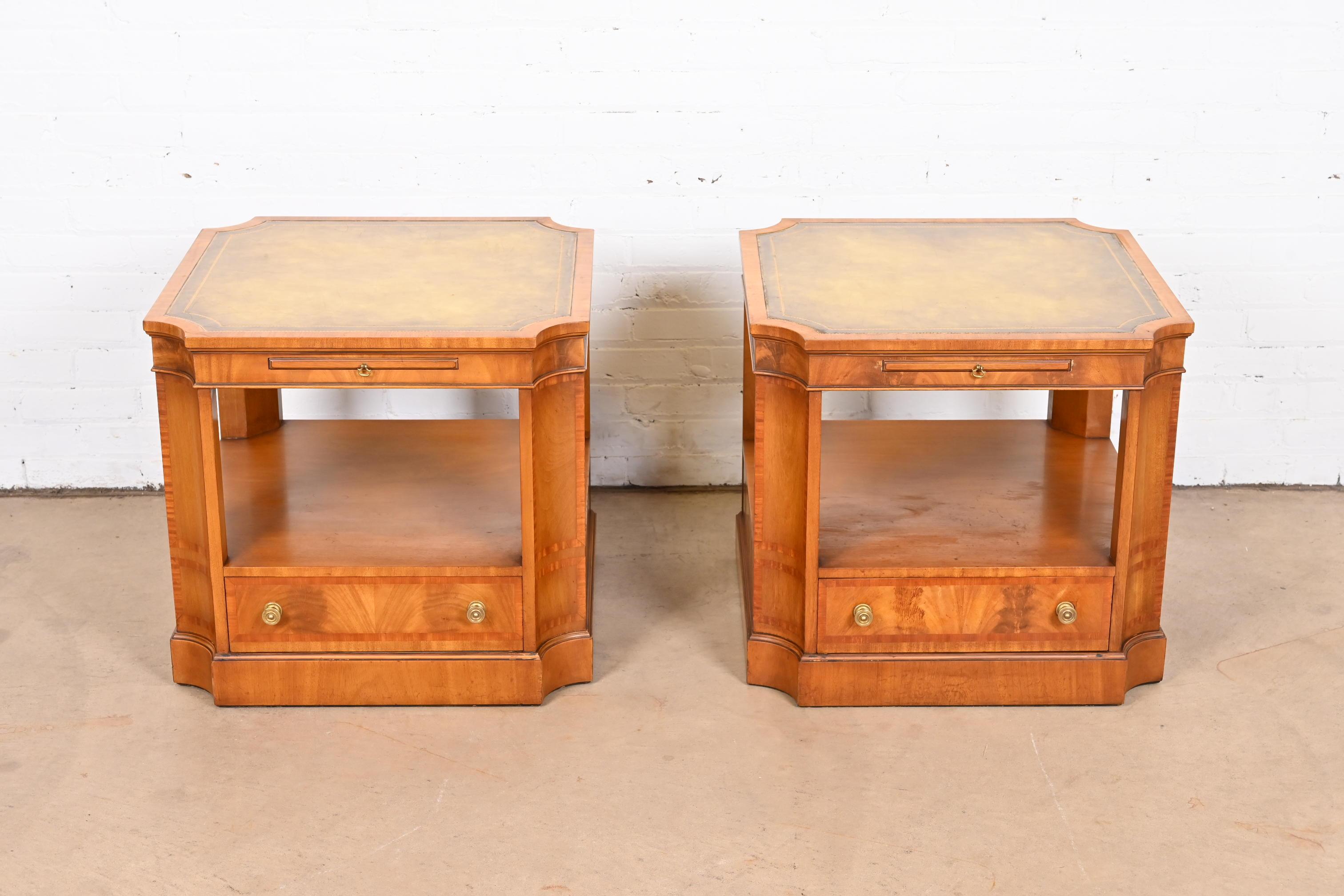 A gorgeous pair of Regency or Georgian style two-tier side tables or nightstands

By Baker Furniture

USA, circa 1950s

Banded flame mahogany, with embossed green leather tops, and original brass hardware

Measures: 24