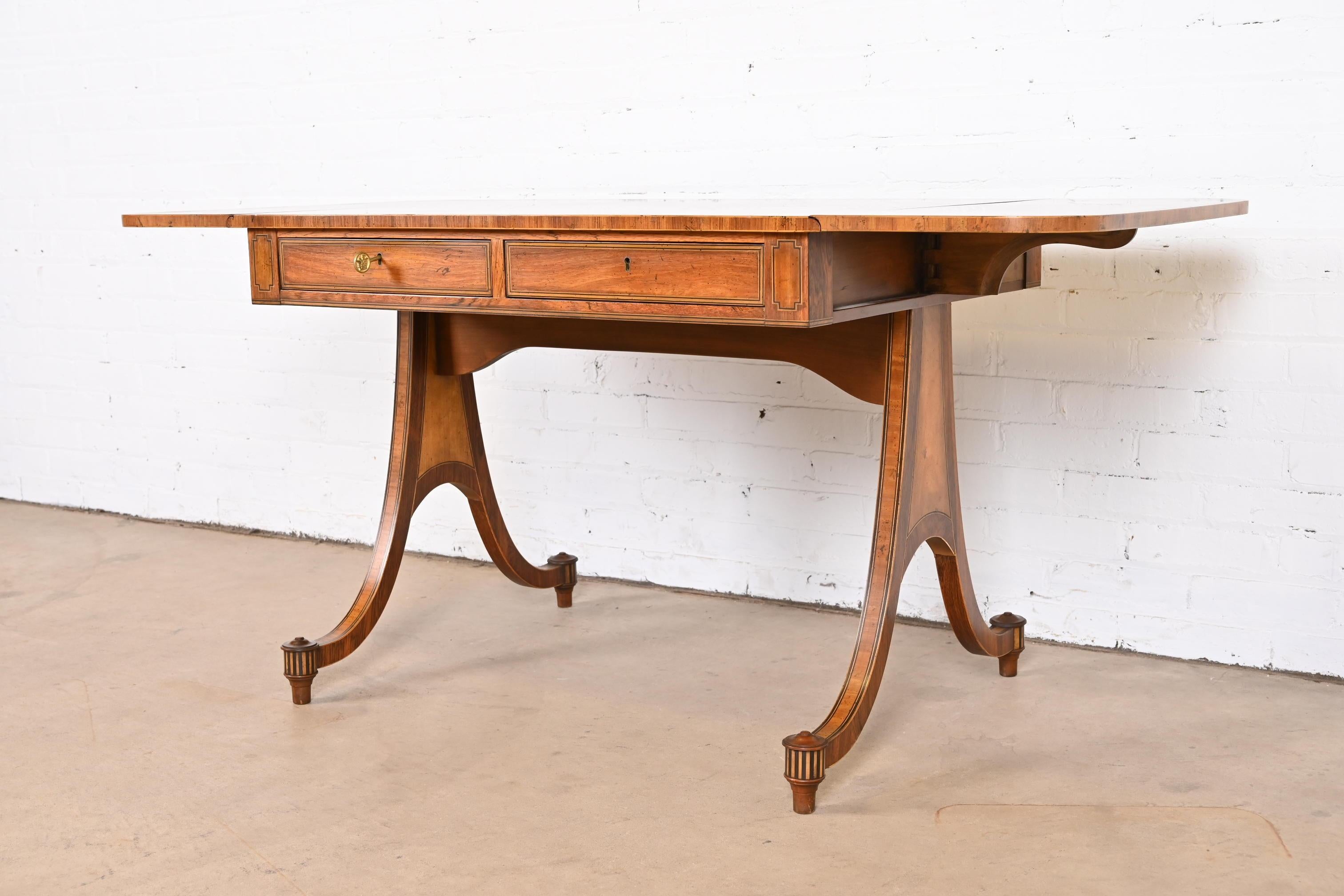 An exceptional Regency or Georgian style drop leaf writing desk or console table

By Baker Furniture

USA, circa 1960s

Walnut, with satinwood banding, and ebony and satinwood inlay. Drawers lock, and original key is included.

Measures: