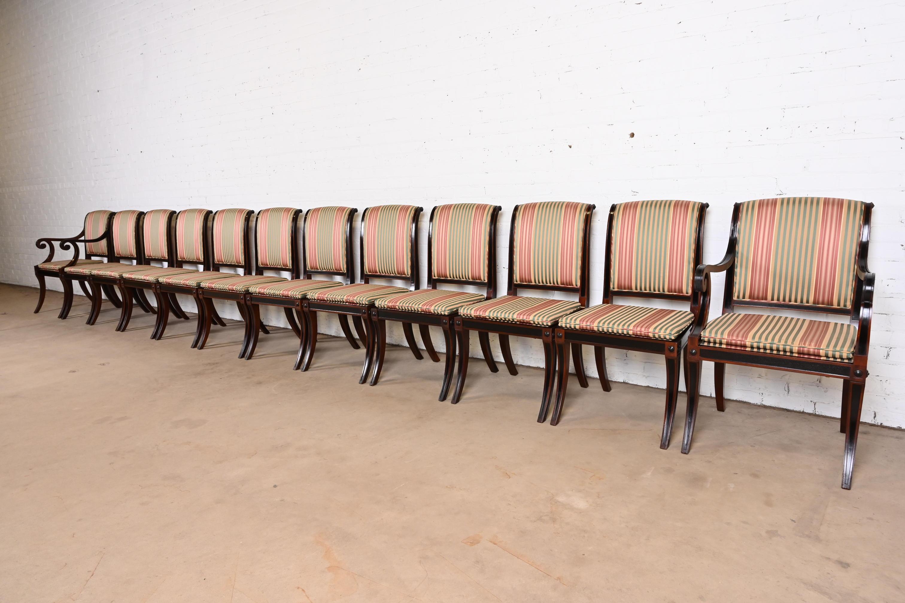 Ein prächtiger Satz von zwölf Esszimmerstühlen im Regency-, neoklassischen oder Empire-Stil

Von Baker Furniture

USA, Ende des 20. Jahrhunderts

Geschnitztes Mahagoni und ebonisierte Rahmen, mit gestreifter