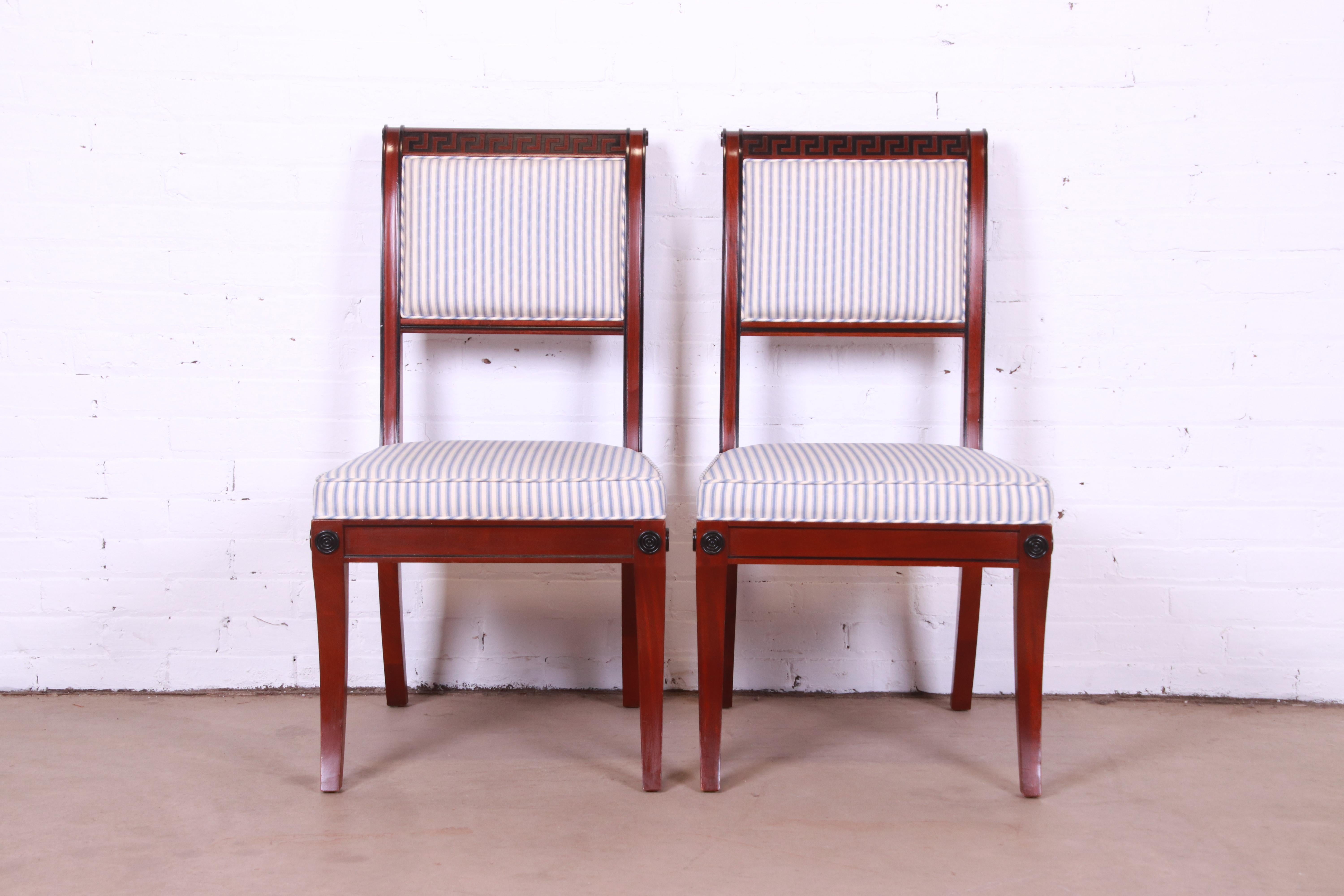 A gorgeous pair of Regency or neoclassical style side chairs or dining chairs

By Baker Furniture

USA, late 20th century

Solid carved mahogany frames, with ebonized Greek key design, and blue & white striped upholstered seats.

Measures: