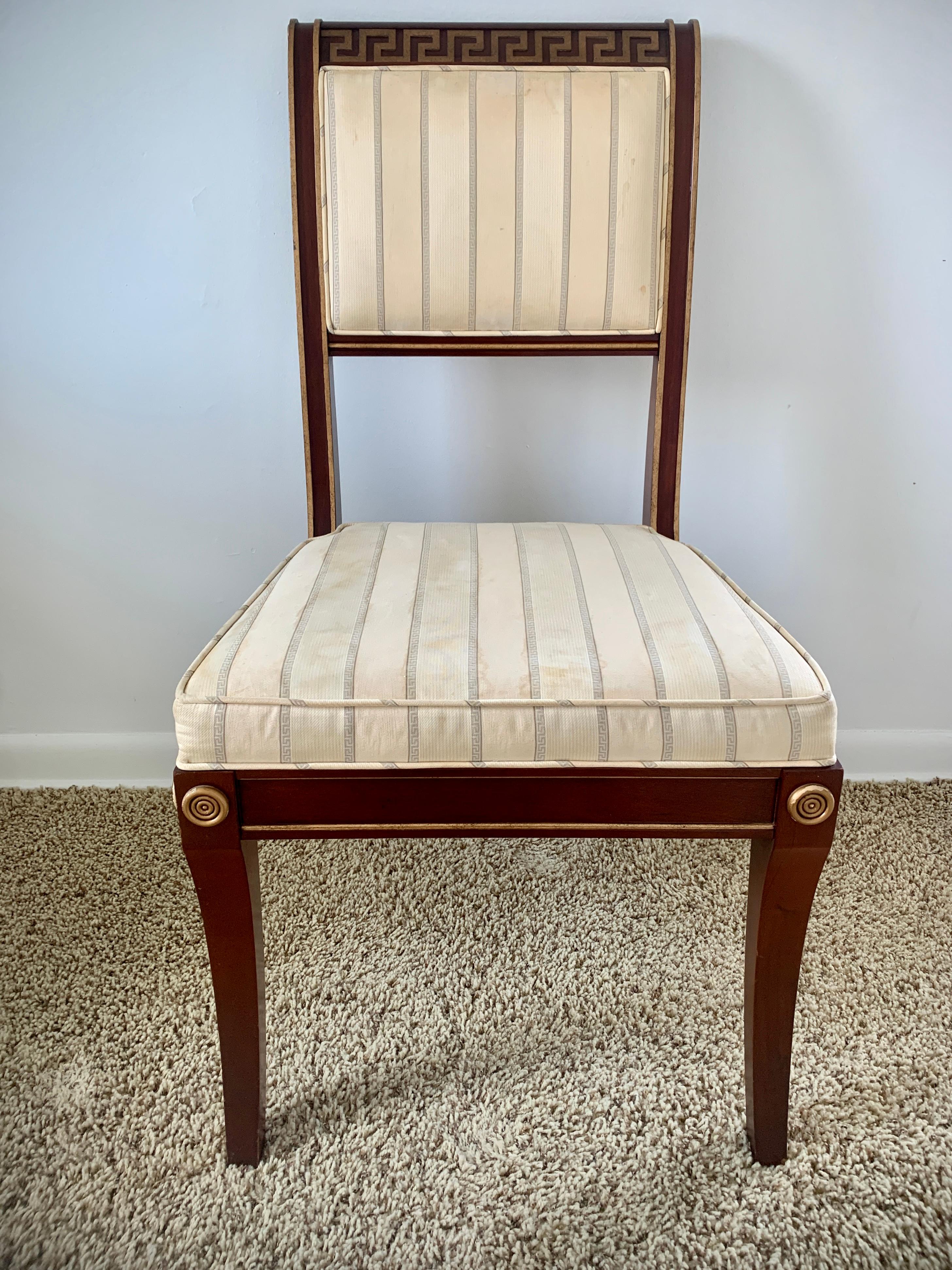 A gorgeous Regency or Neoclassical style dining chair

By Baker Furniture

USA, Late 20th Century

Solid carved mahogany frames, with giltwood Greek key design, and blue & white striped upholstered seat.

Measures: 20.75
