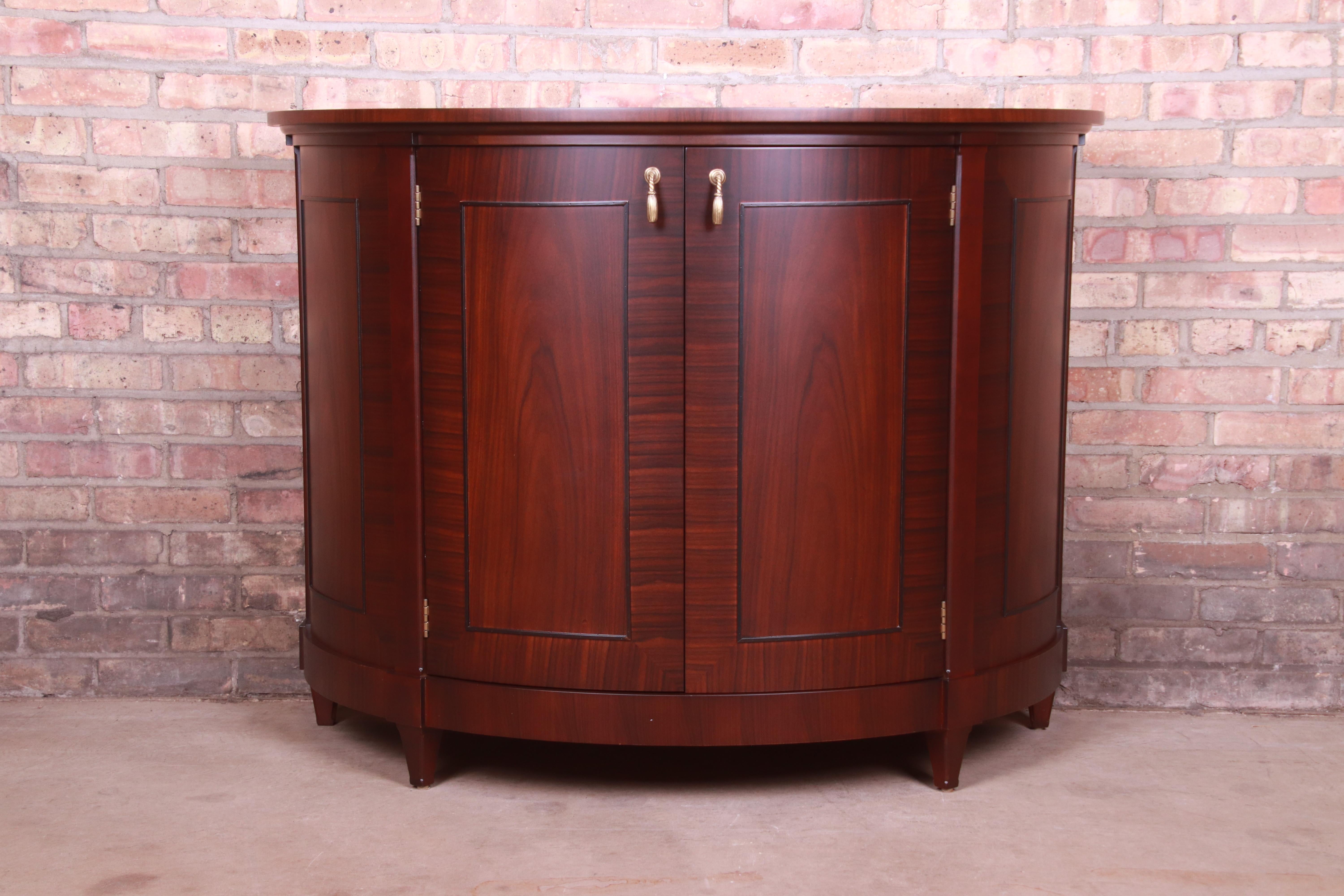 A gorgeous Regency style demilune console or bar cabinet

By Baker Furniture

USA, Circa 1990s

Mahogany, with original brass hardware.

Measures: 47.25