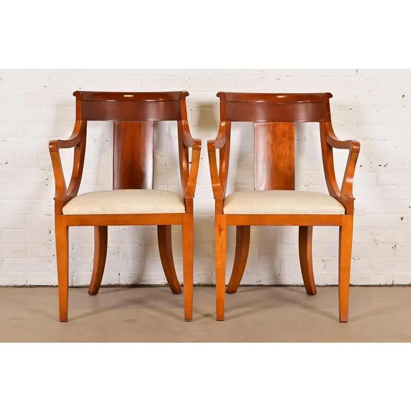 A gorgeous pair of Regency style armchairs or dining captain chairs

By Baker Furniture

USA, Circa 1980s

Solid cherry wood frames, with upholstered seats.

Measures: 23.25