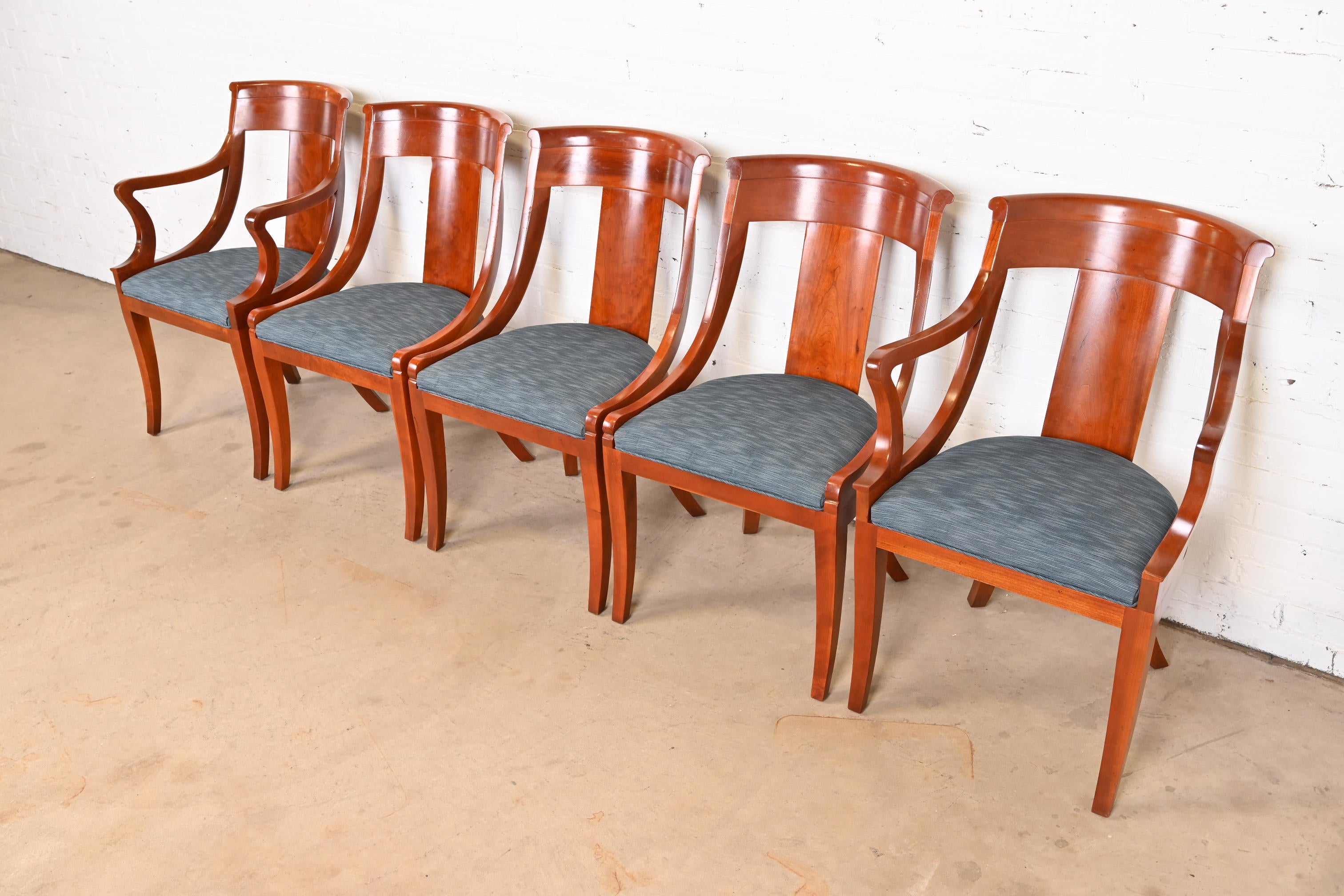 A beautiful set of five Regency or Neoclassical style dining chairs

By Baker Furniture

USA, Circa 1980s

Solid cherry wood frames, with upholstered seats.

Measures:
Side chairs - 20.5