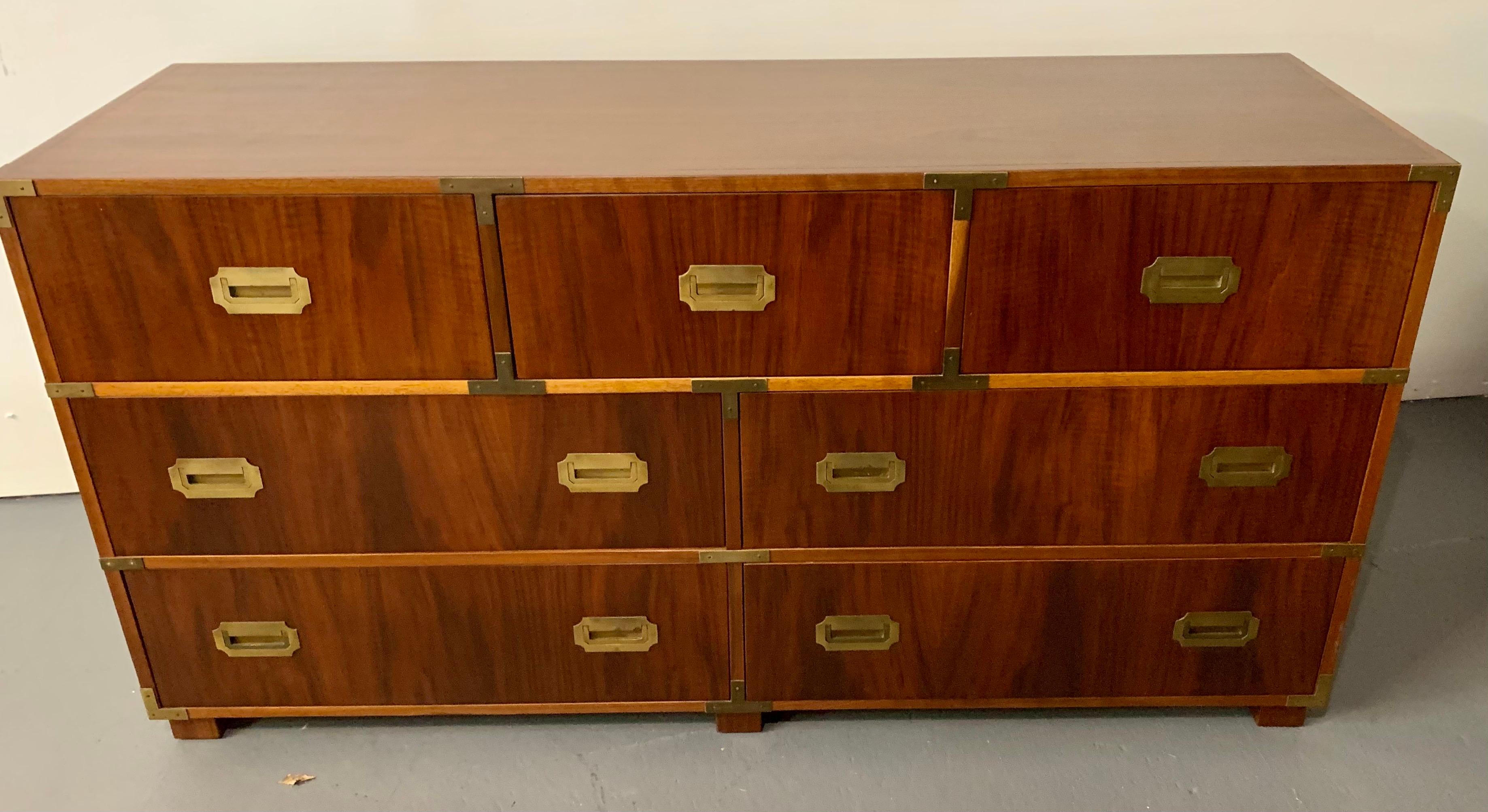 Vintage campaign style dresser with seven dovetailed drawers and brass hardware and pulls. Solid high-quality construction by Baker Furniture. All Baker hallmarks are present. Note we have the smaller companion dresser also exclusively on 1stDibs.