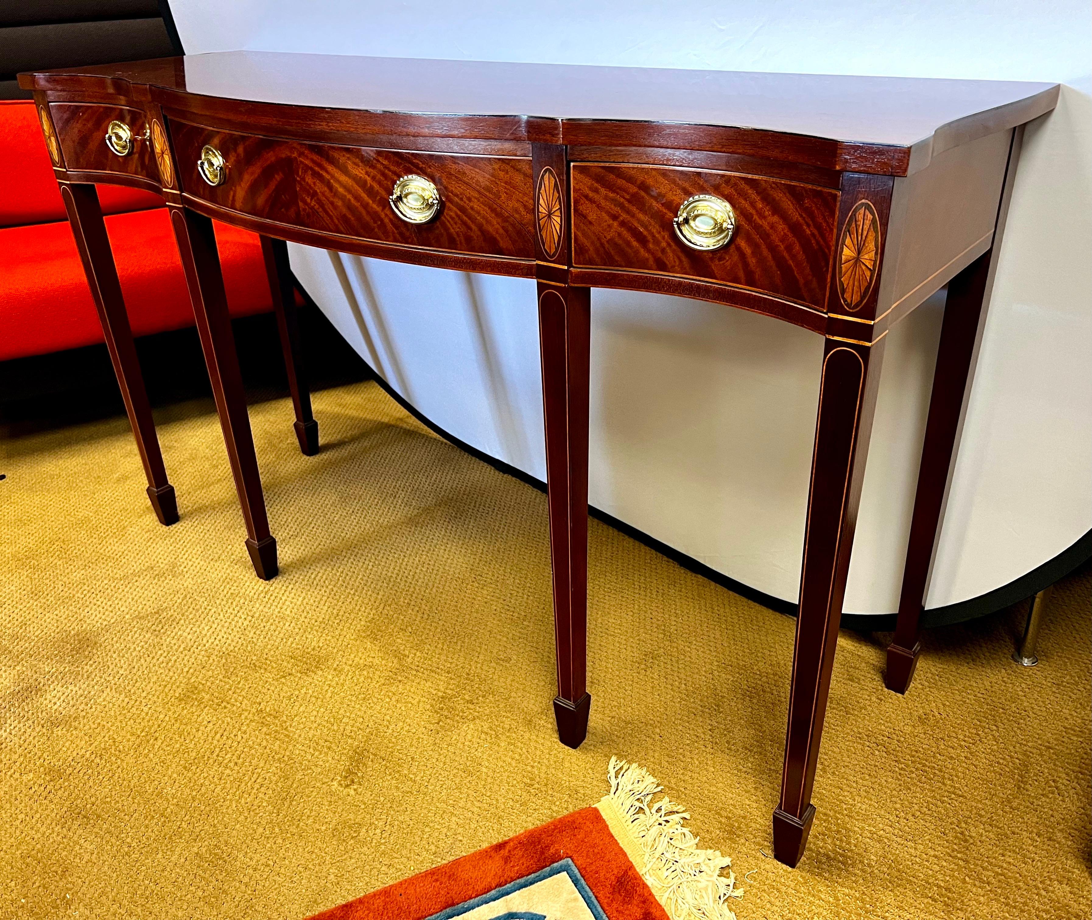 Baker Furniture Historic Charleston Federal inlaid mahogany console table showcases the finest craftsmanship with intricate oval and line inlay and brass hardware.  A versatile piece for your dining or living room as well as a study or foyer.  It's